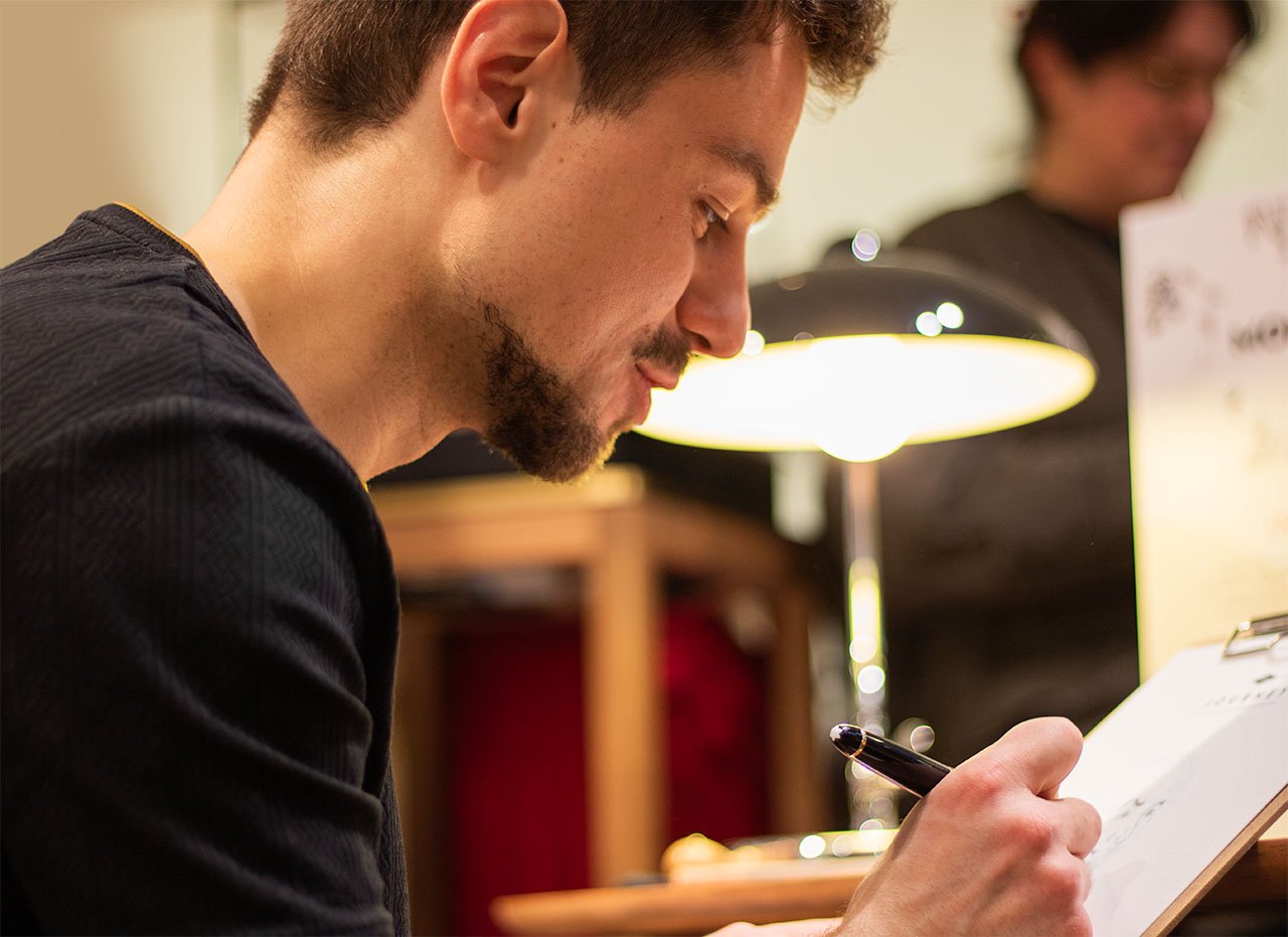 Ein junger Mann schreibt auf einem Whiteboard bei einer Arbeitssitzung in einem Büro.