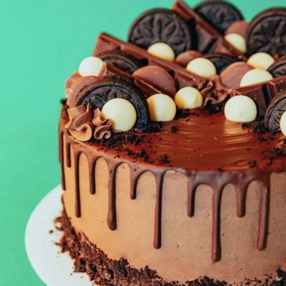 vegan chocolate celebration drip cake with Oreos, chocolate buttons and crumble