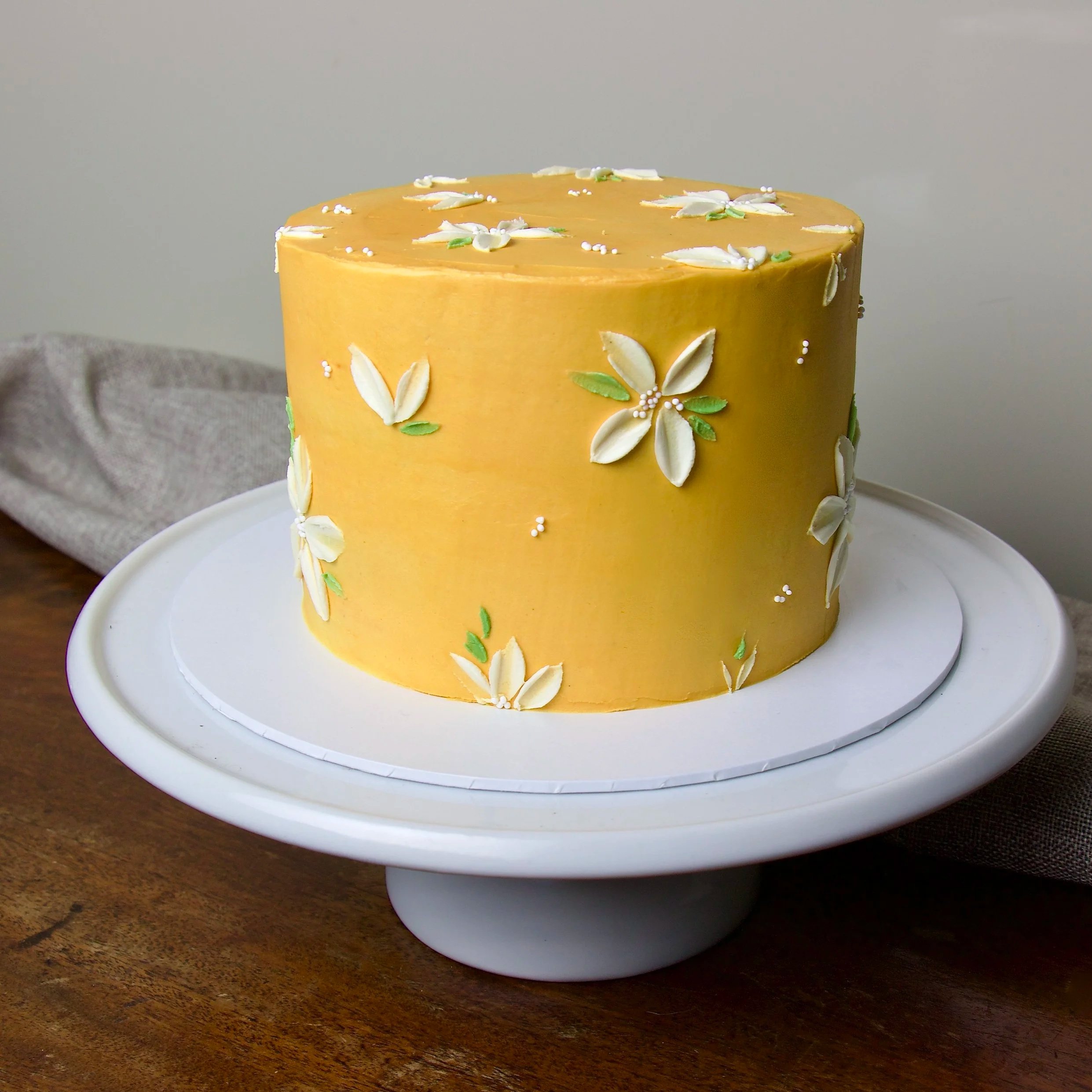 Yellow celebration cake with hand-painted buttercream floral design