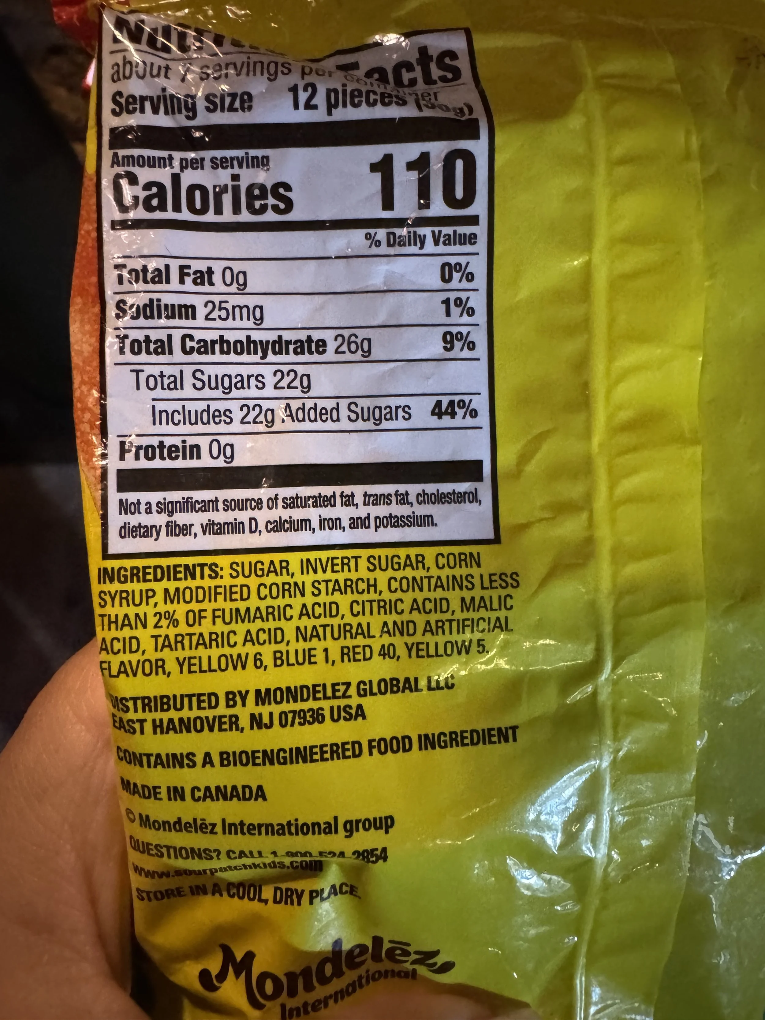 Nutritional information and ingredients label on a candy package. It includes details on serving size, calories, total fat, sodium, carbohydrates, and sugars. Ingredients listed are sugar, invert sugar, corn syrup, modified corn starch, and various acids and dyes. The product is made by Mondelez Global LLC and contains bioengineered food ingredients.