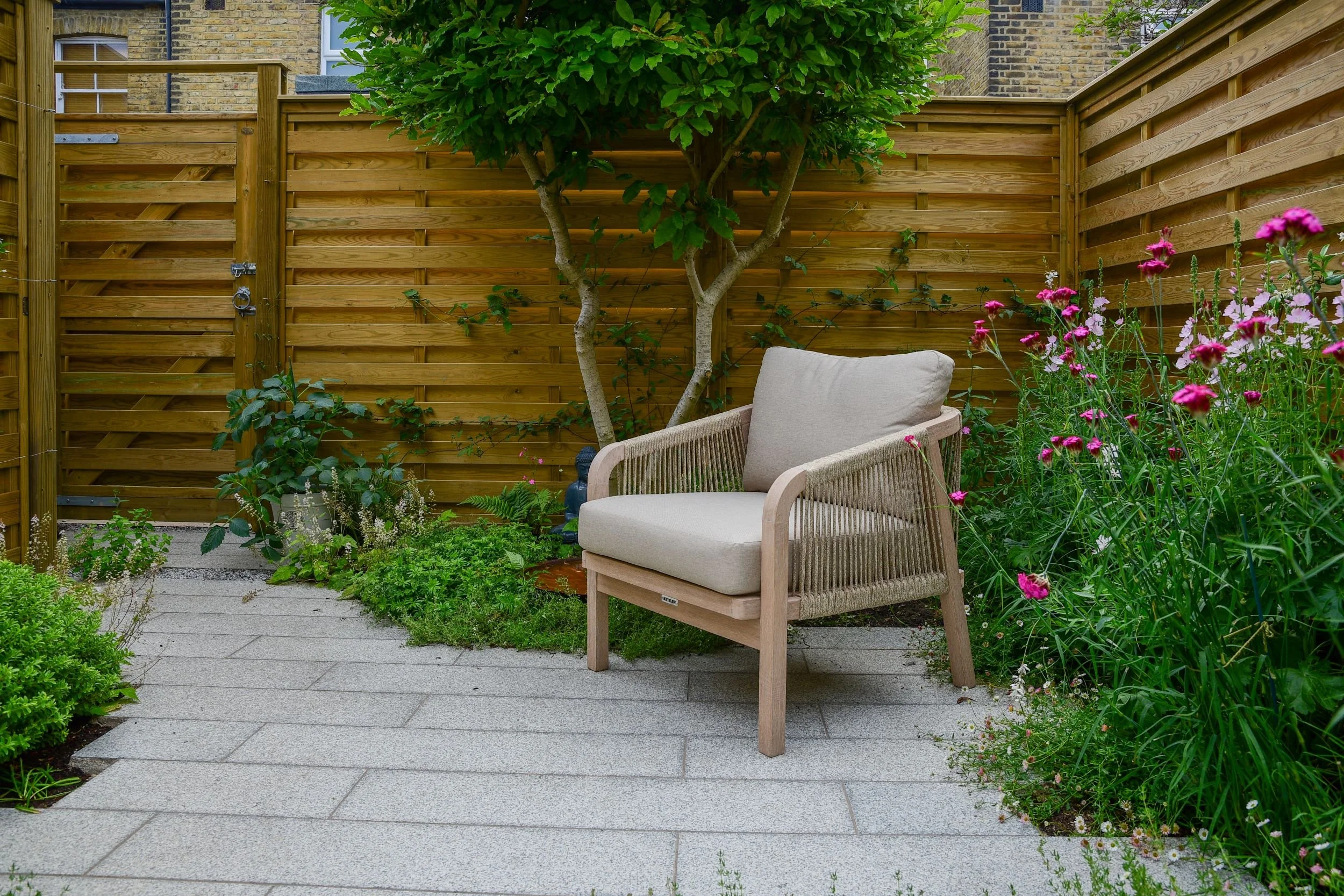 Finished corner of a Twickenham courtyard garden showing hit-and-miss timber fencing, gate and granite paving. Built by vladthelandscaper.co.uk

The completed version of the same corner shown during construction — hit-and-miss timber fencing and a ma