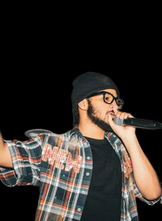 DJ 2P Tha Kidd man wearing a black beanie, glasses, and a plaid shirt with