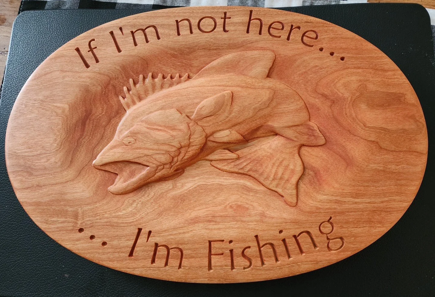 Wooden plaque with fishing-themed carving featuring a fish and the text 'If I'm not here... I'm fishing'.