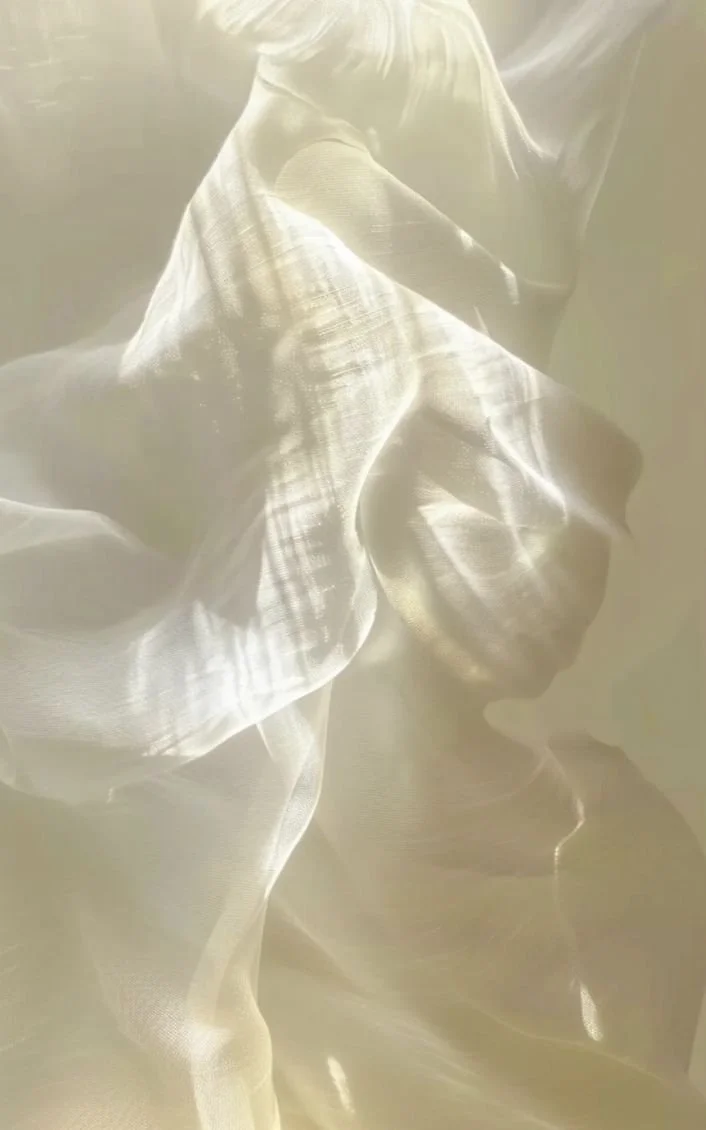 Close-up of a crumpled, silky, and shiny fabric with light reflecting off its surface.