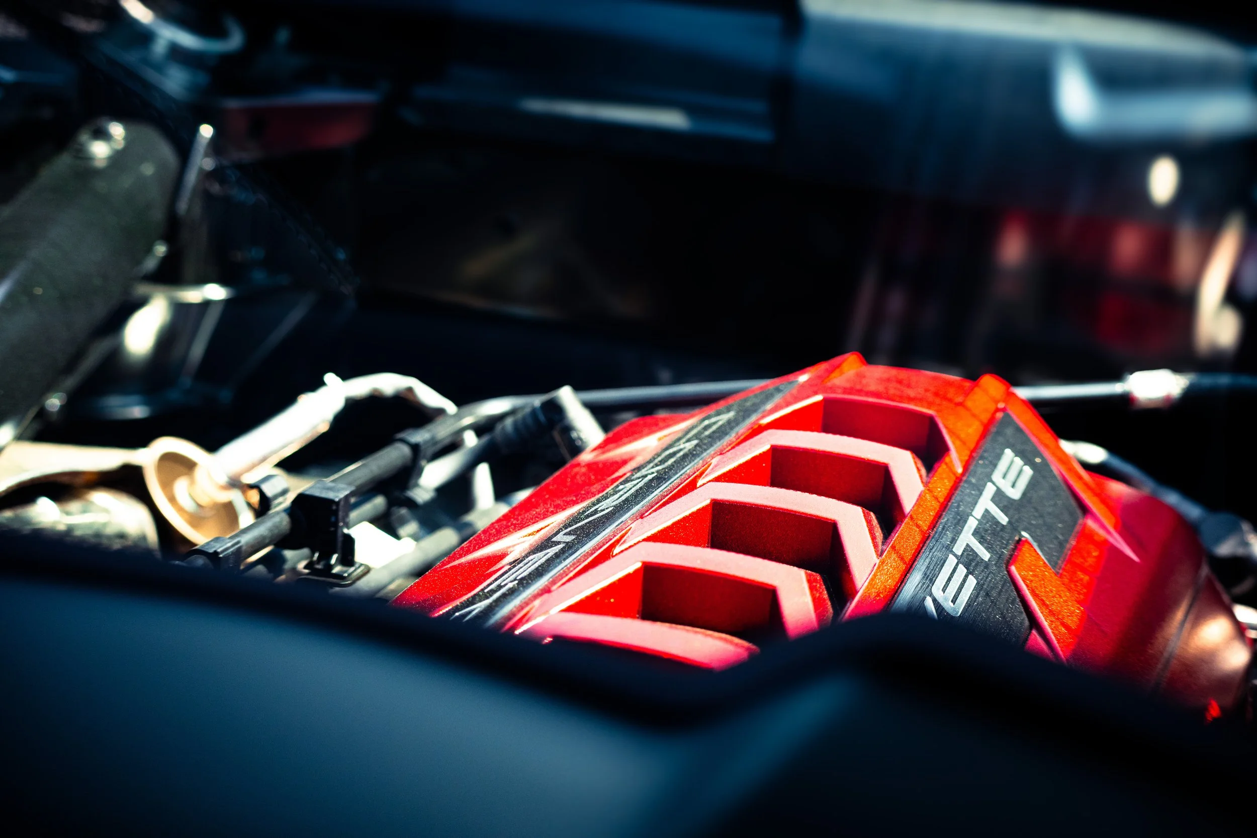 Close-up of a red and black supercharged engine bay of a racing car.