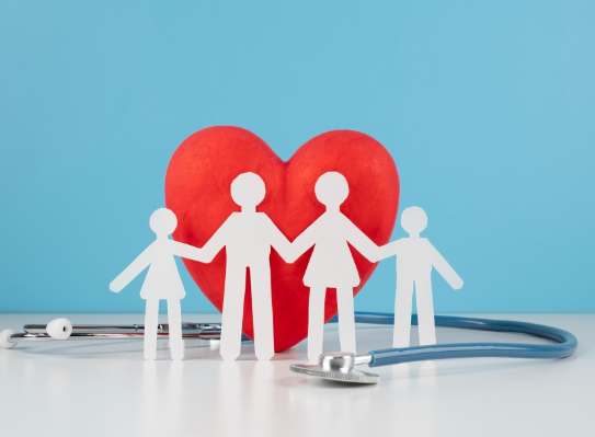 Figuras de papel de una familia frente a un corazón rojo y un estetoscopio sobre fondo azul.