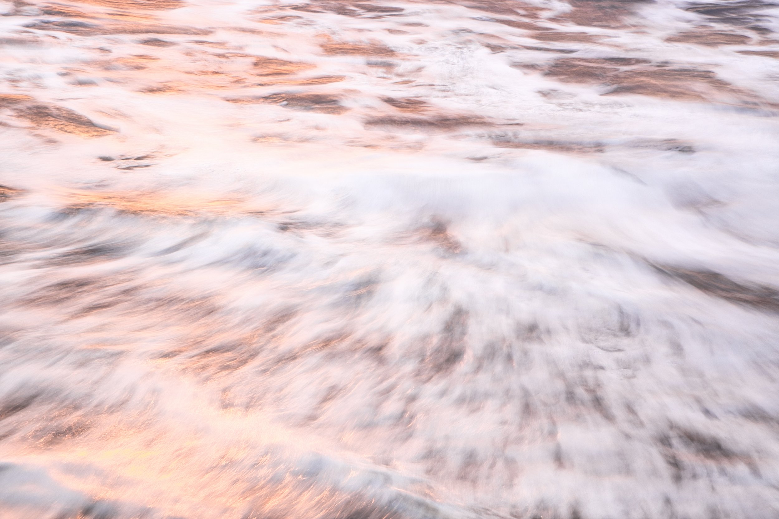 Photographie fine art de vague en pose lente au Costa Rica, avec écume vaporeuse et reflets rosés, dorés et cuivrés au coucher du soleil, tirée sur papier métallique Hahnemühle.