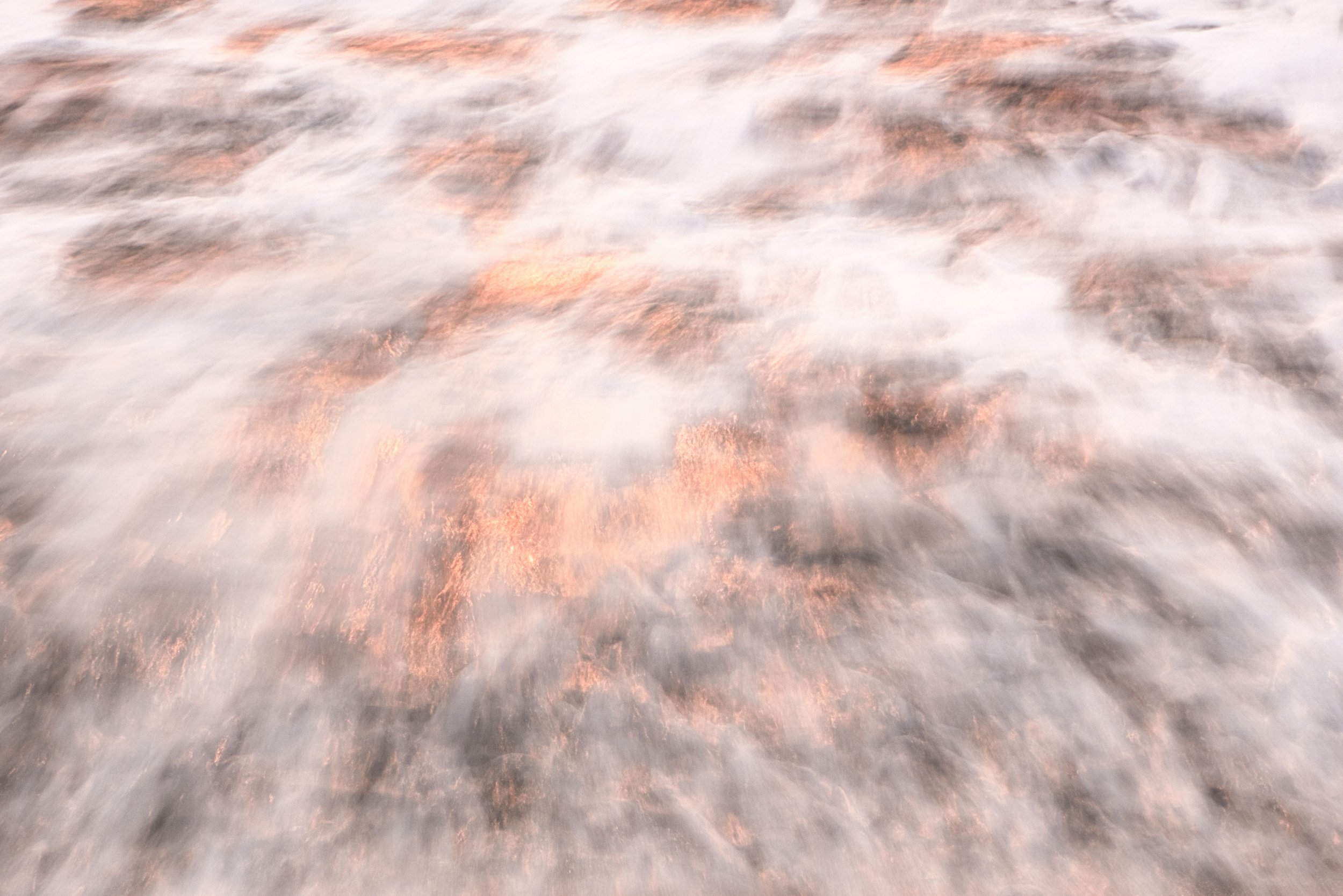 Photographie fine art de vague en pose lente au Costa Rica, avec écume vaporeuse et reflets rosés, dorés et cuivrés au coucher du soleil, tirée sur papier métallique Hahnemühle.