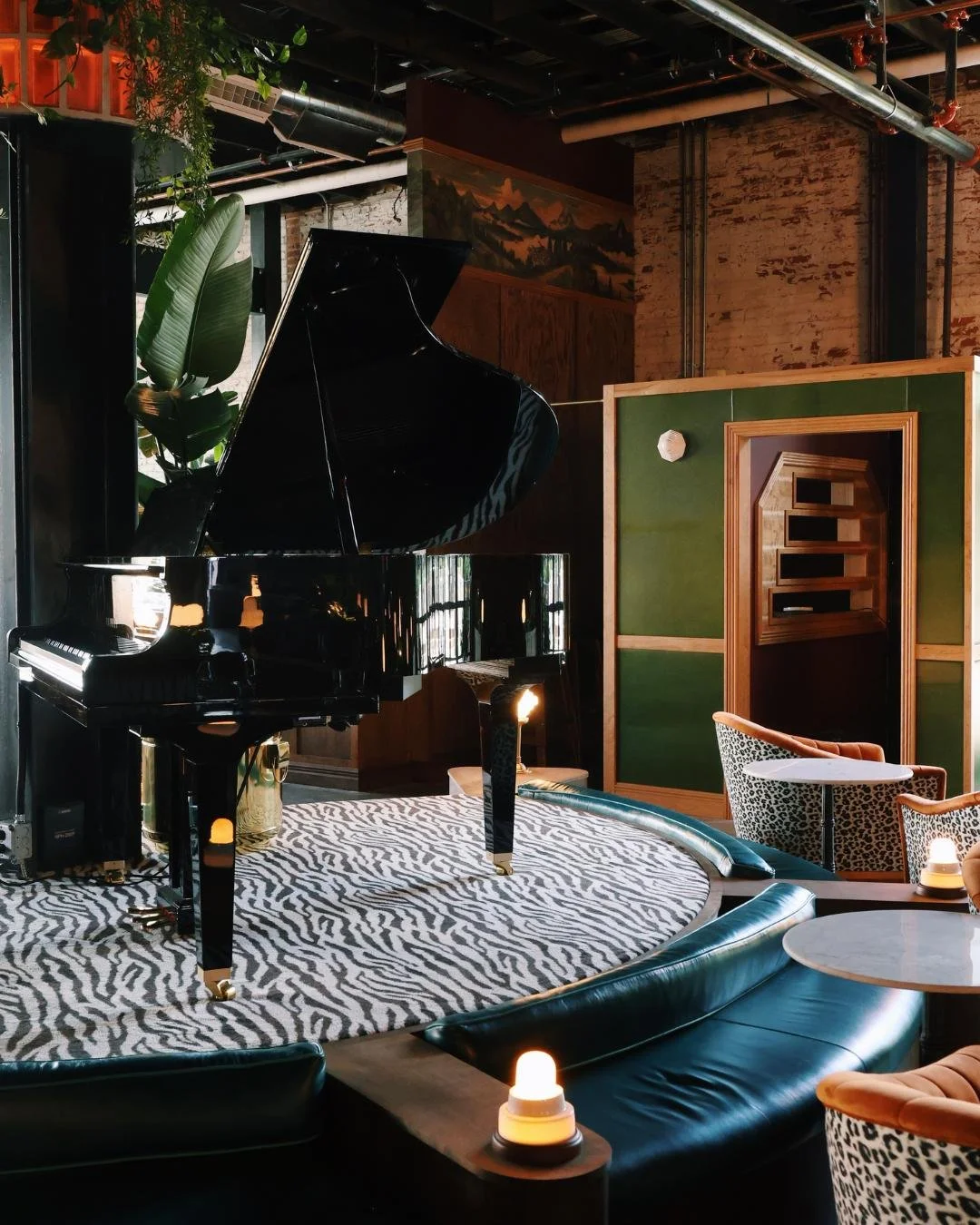 A grand piano sitting on a stage with zebra carpet in the middle of Red Herring Restaurant's Dining Room