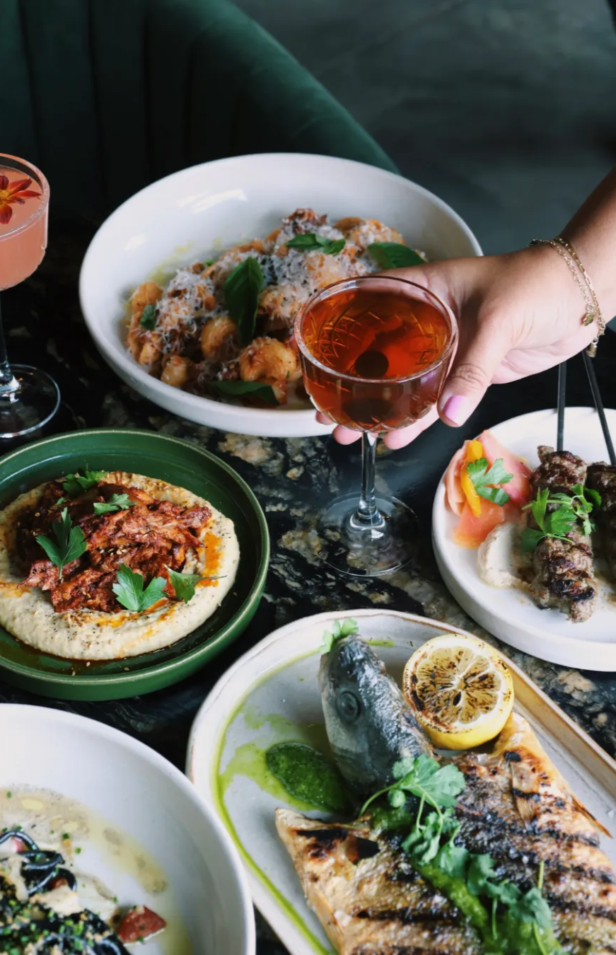A line up of chef prepared dishes at Red Herring Restaurant with pastas, small plates and a grilled wood-fired fish 