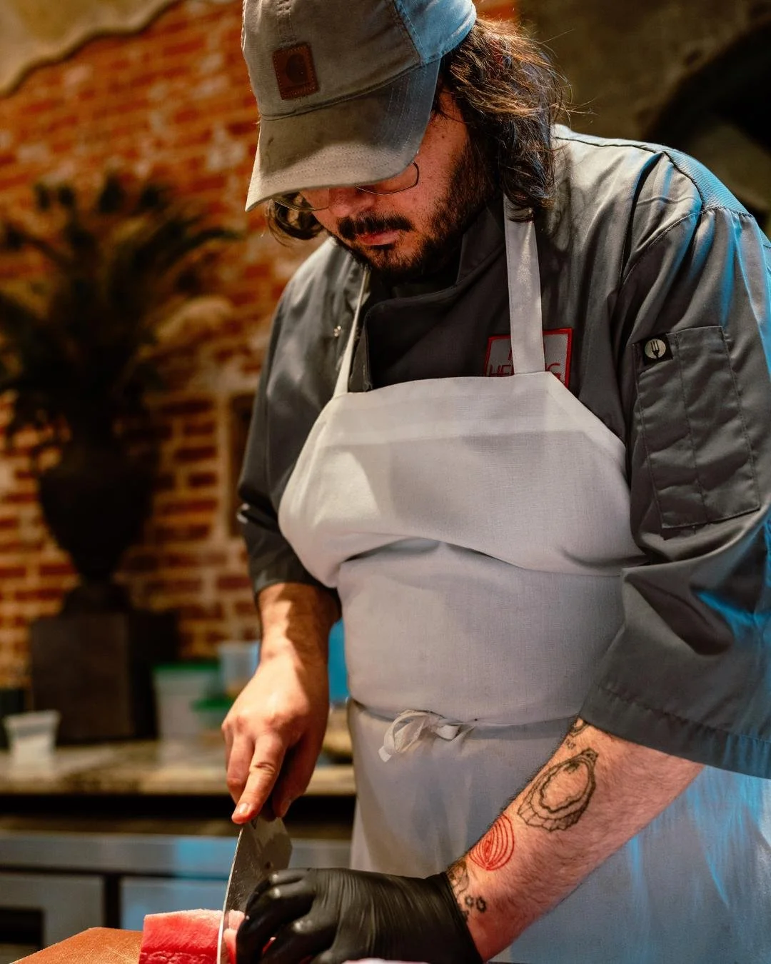 A Red Herring Chef cutting fresh fish by hand at the Raw Oyster Bar