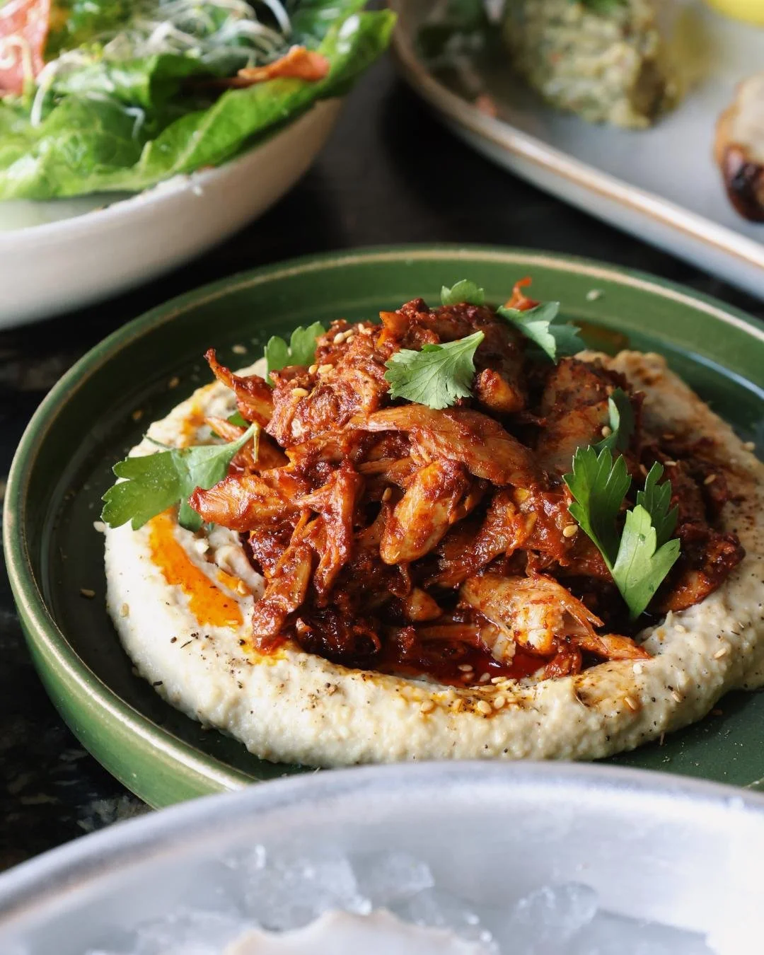 A chef prepared dish with a salad in the background 
