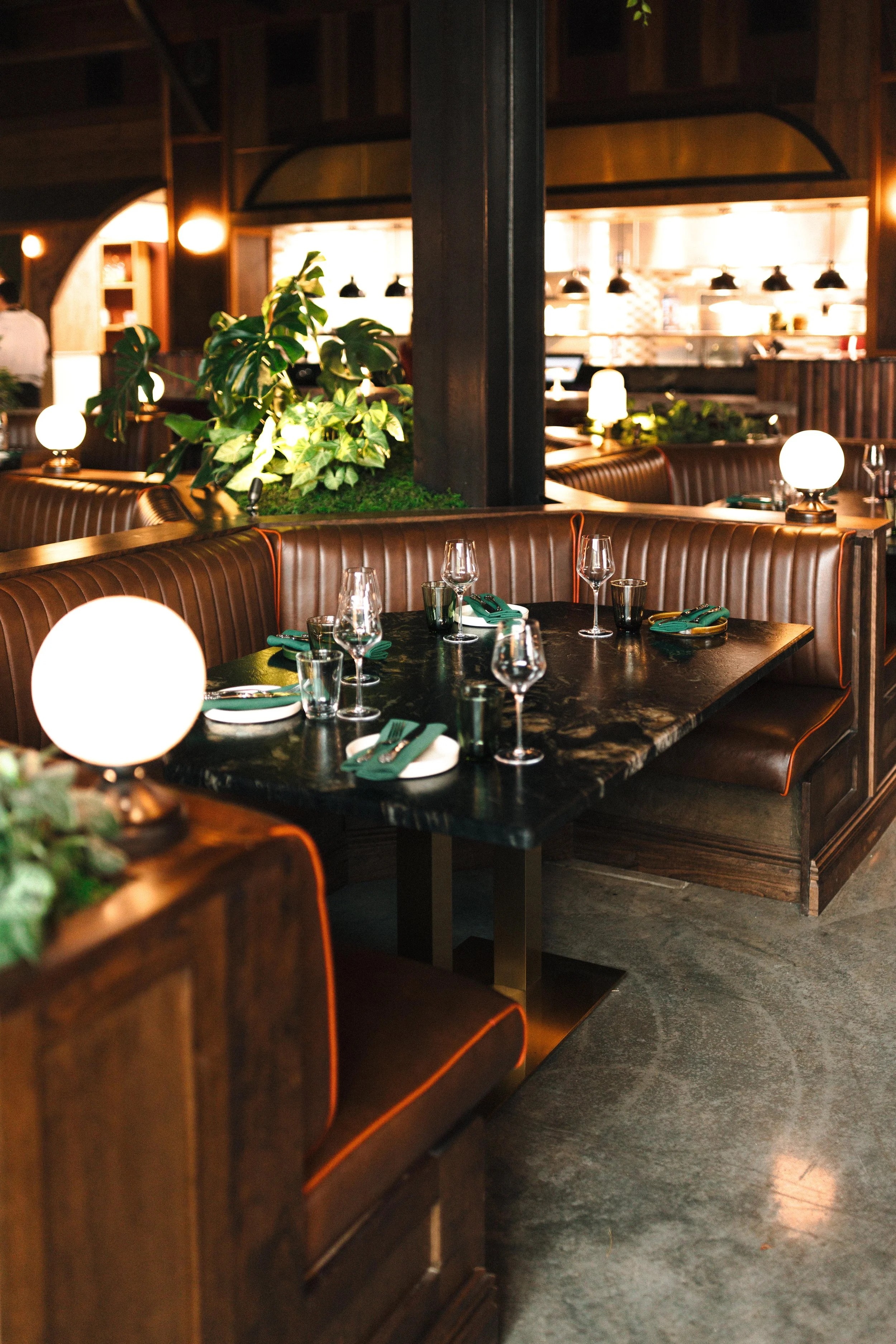 A view of the leather booths at Red Herring Restaurant with the Kitchen Line behind them