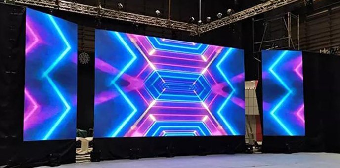 LED screens displaying colorful geometric patterns in a stage setting.