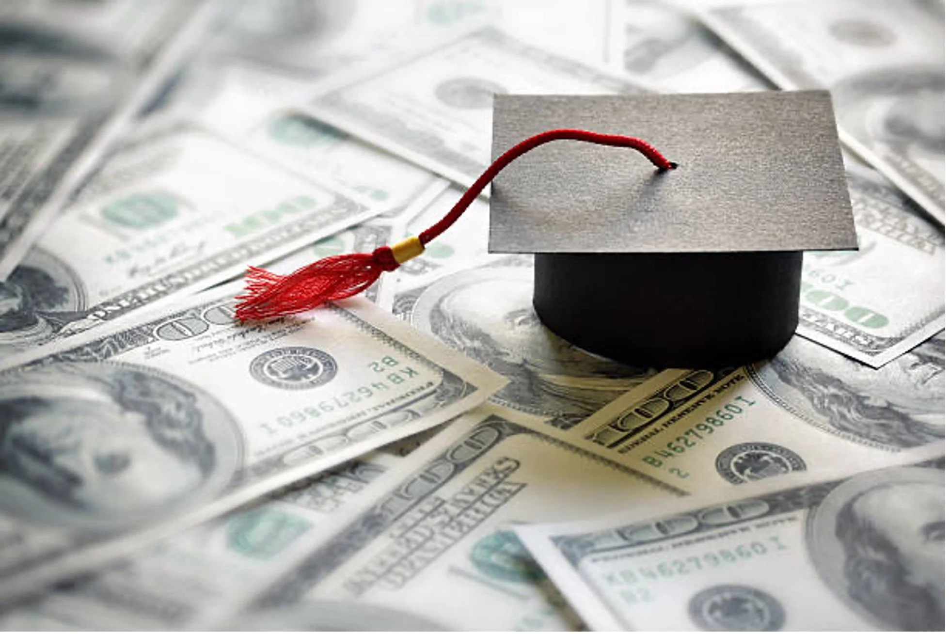 Scholarship - graduation cap with tassel on 100 dollar bills
