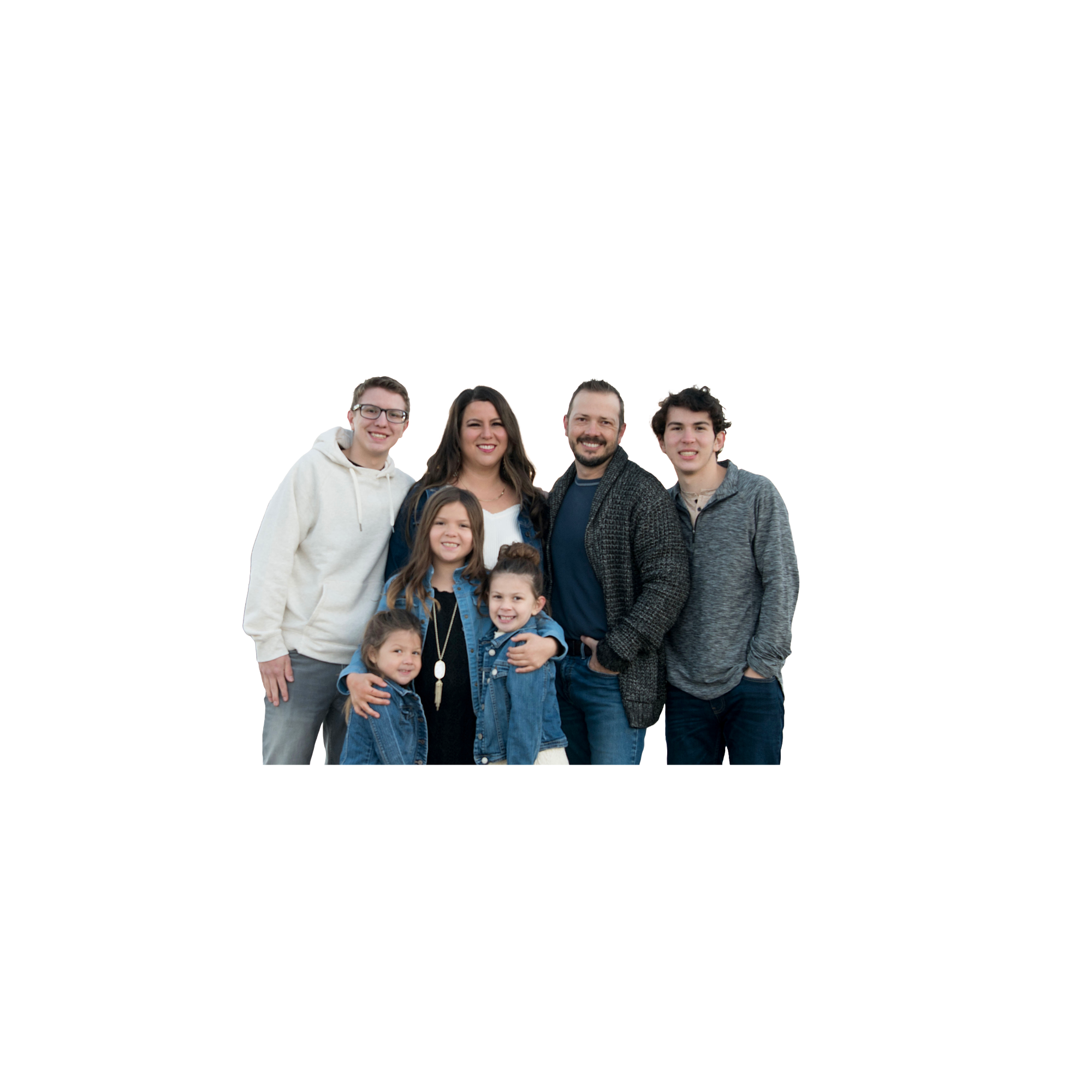 A happy family of seven, including adults and children, standing together inside a stylized white outline of a filming camera, on a black background.