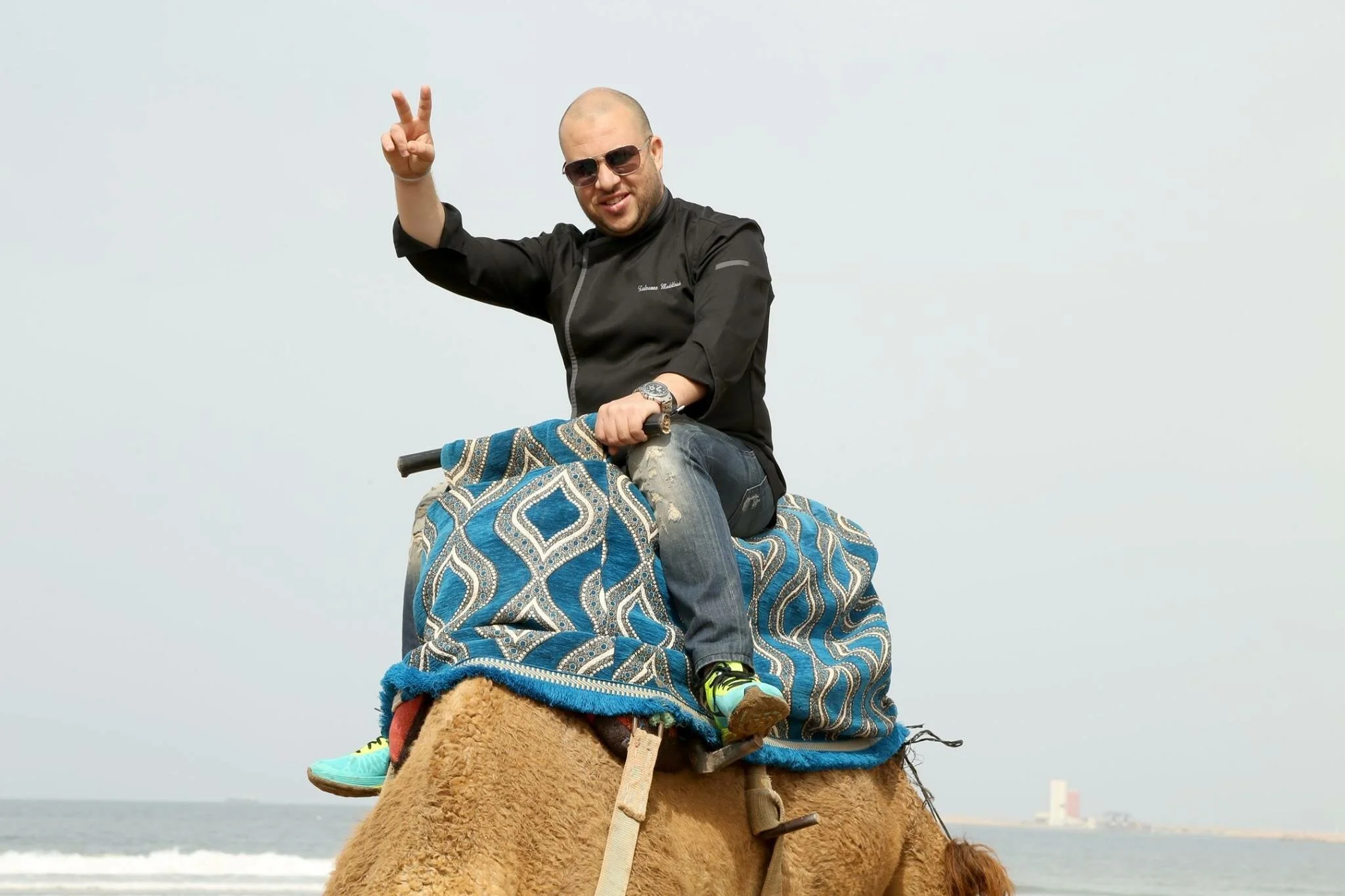 Chef Redouane riding a camel, embodying the freedom of gig work success.