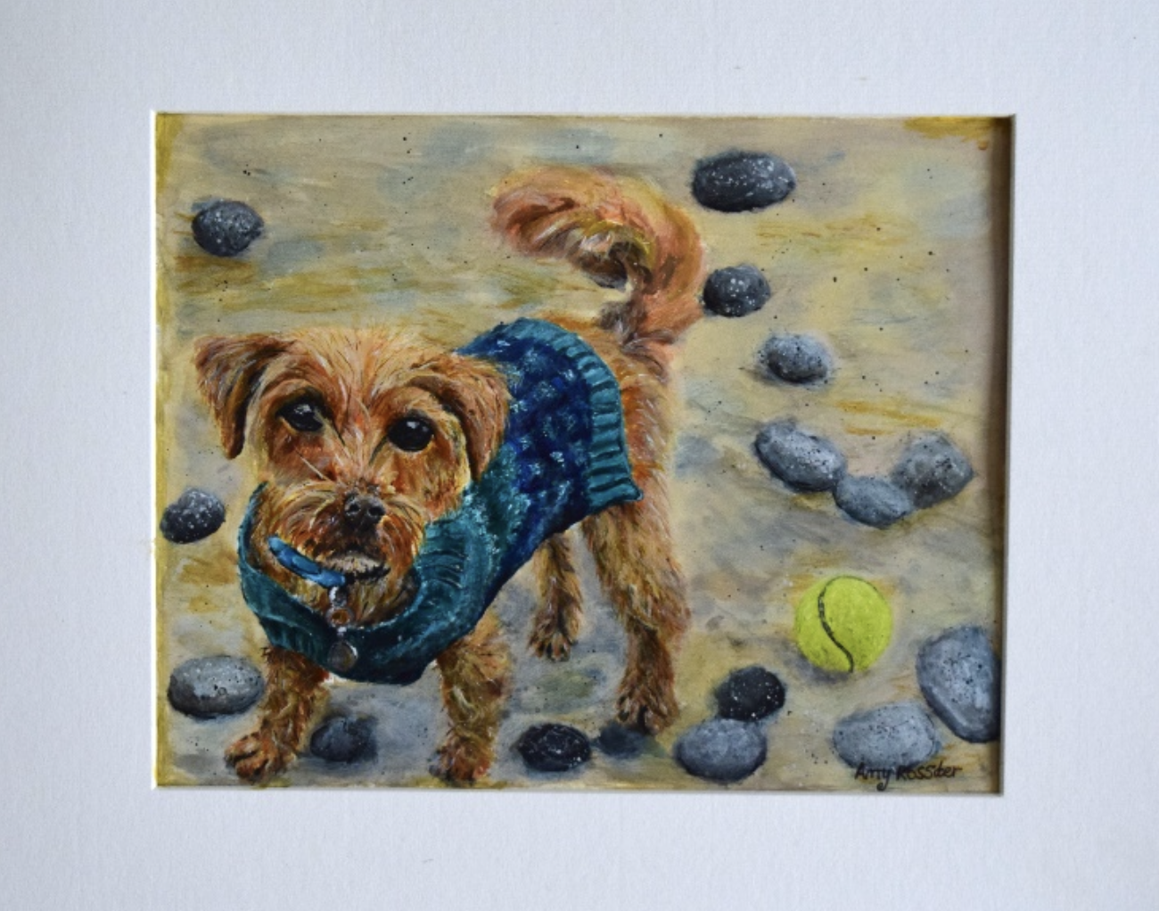 A painting of a small brown dog with a curly tail wearing a blue sweater, standing on a rocky surface with a yellow tennis ball nearby and several scattered rocks.
