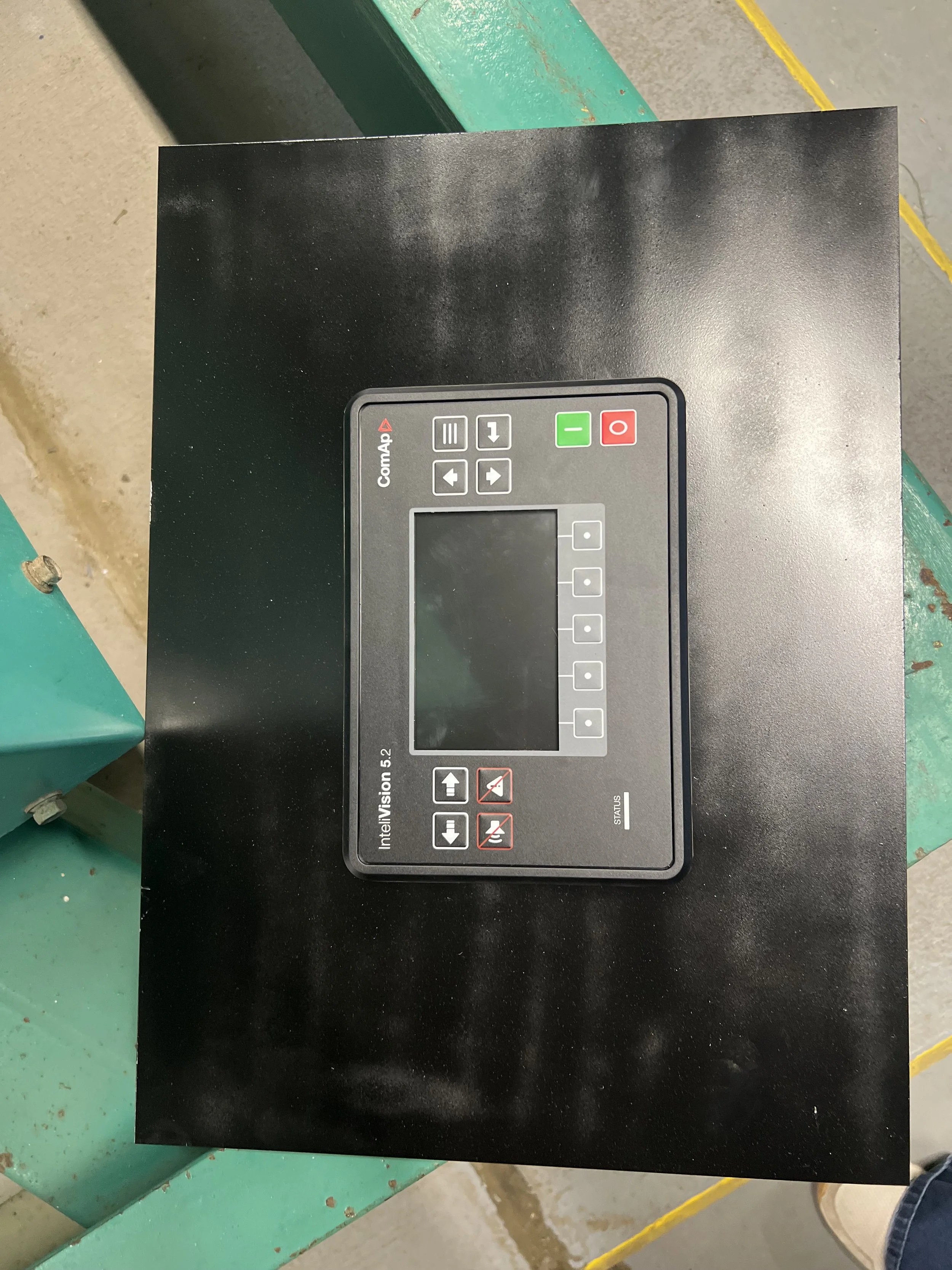 Close-up of a Control Panel labeled 'Intelivision 5.2' with various buttons, a display screen, and status indicators, mounted on a black surface.