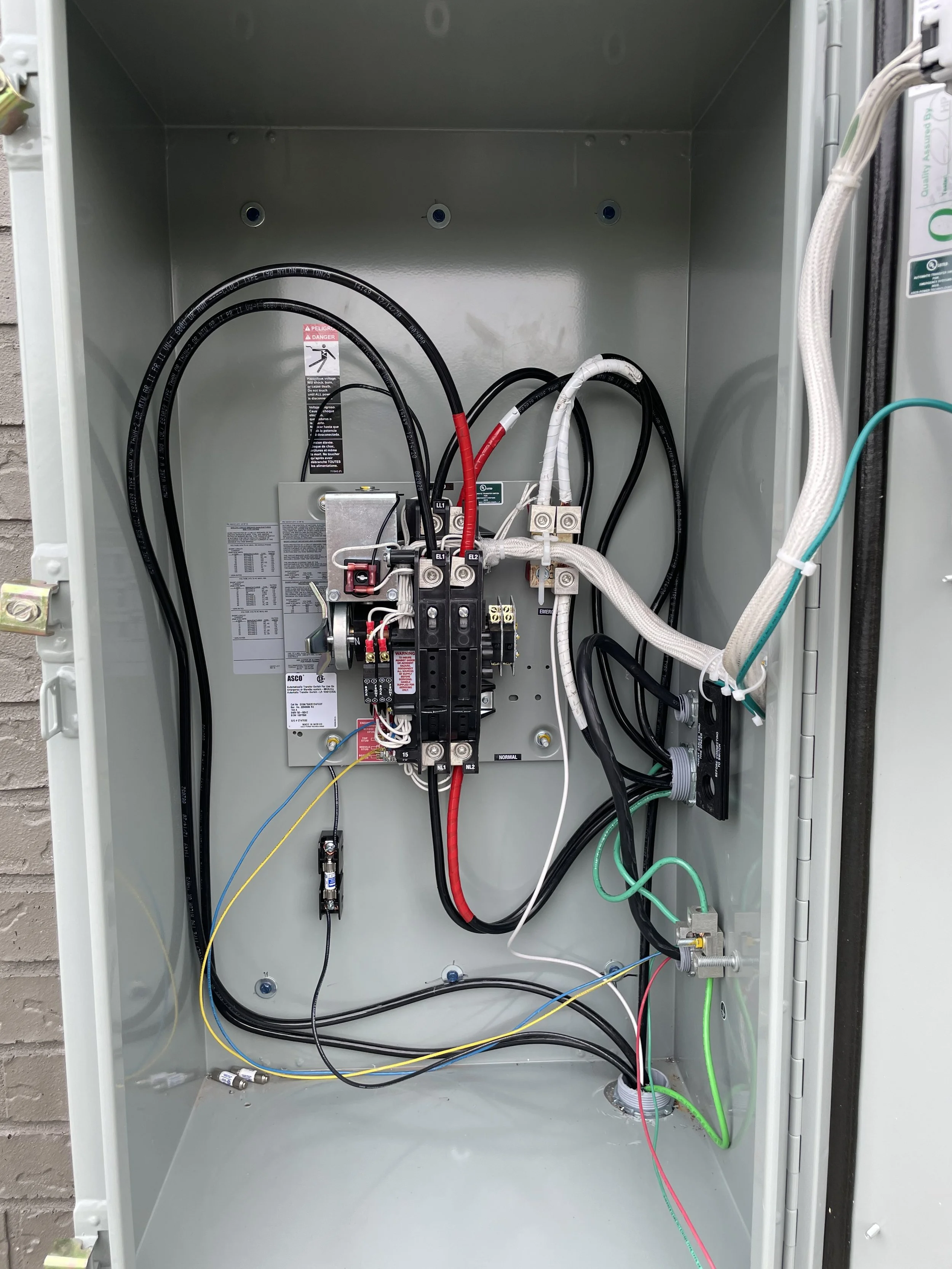 Inside an electrical or utility cabinet with wires, switches, and connections.