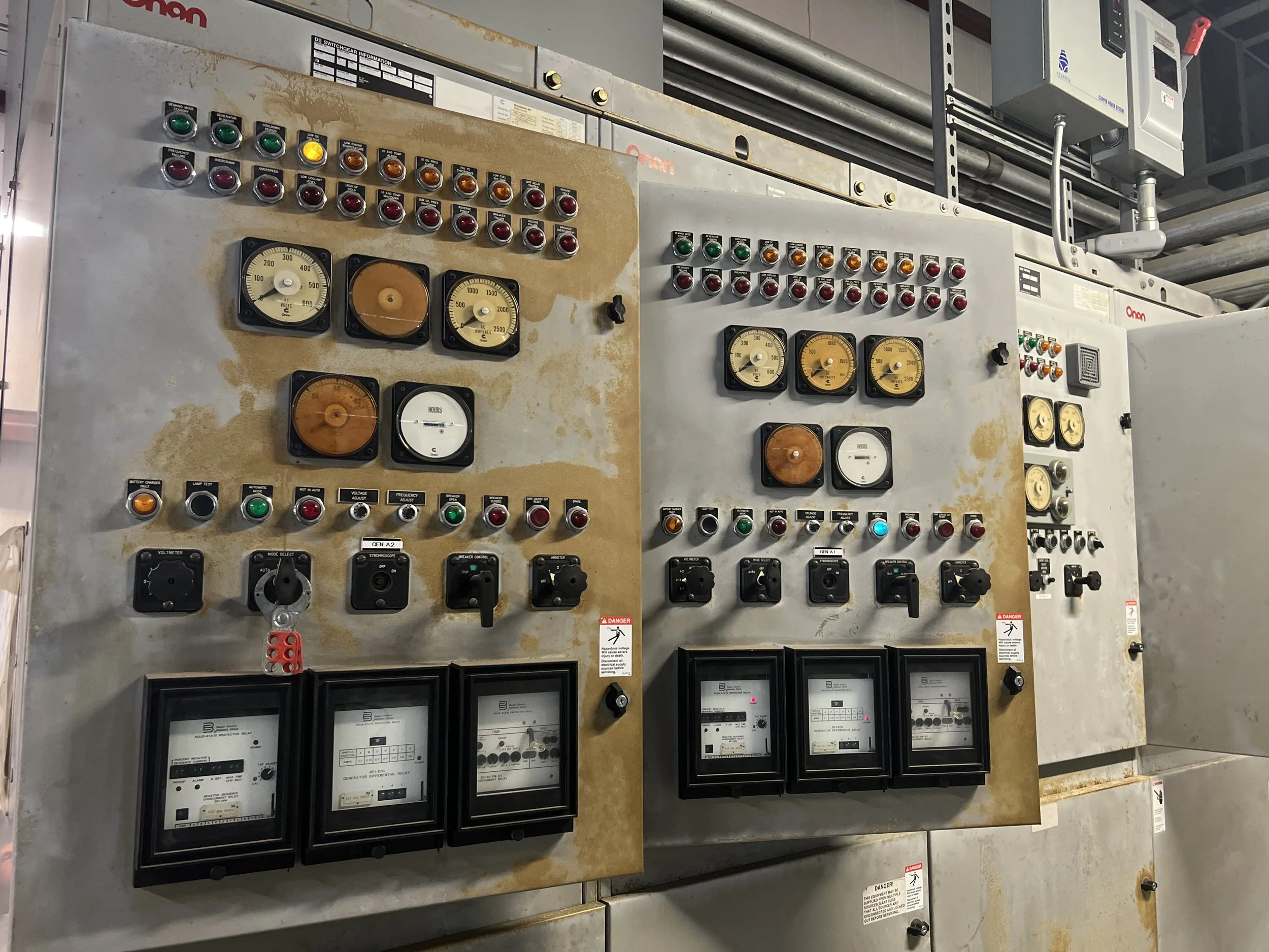 Industrial control panels with switches, gauges, and meters, some showing signs of rust and wear.