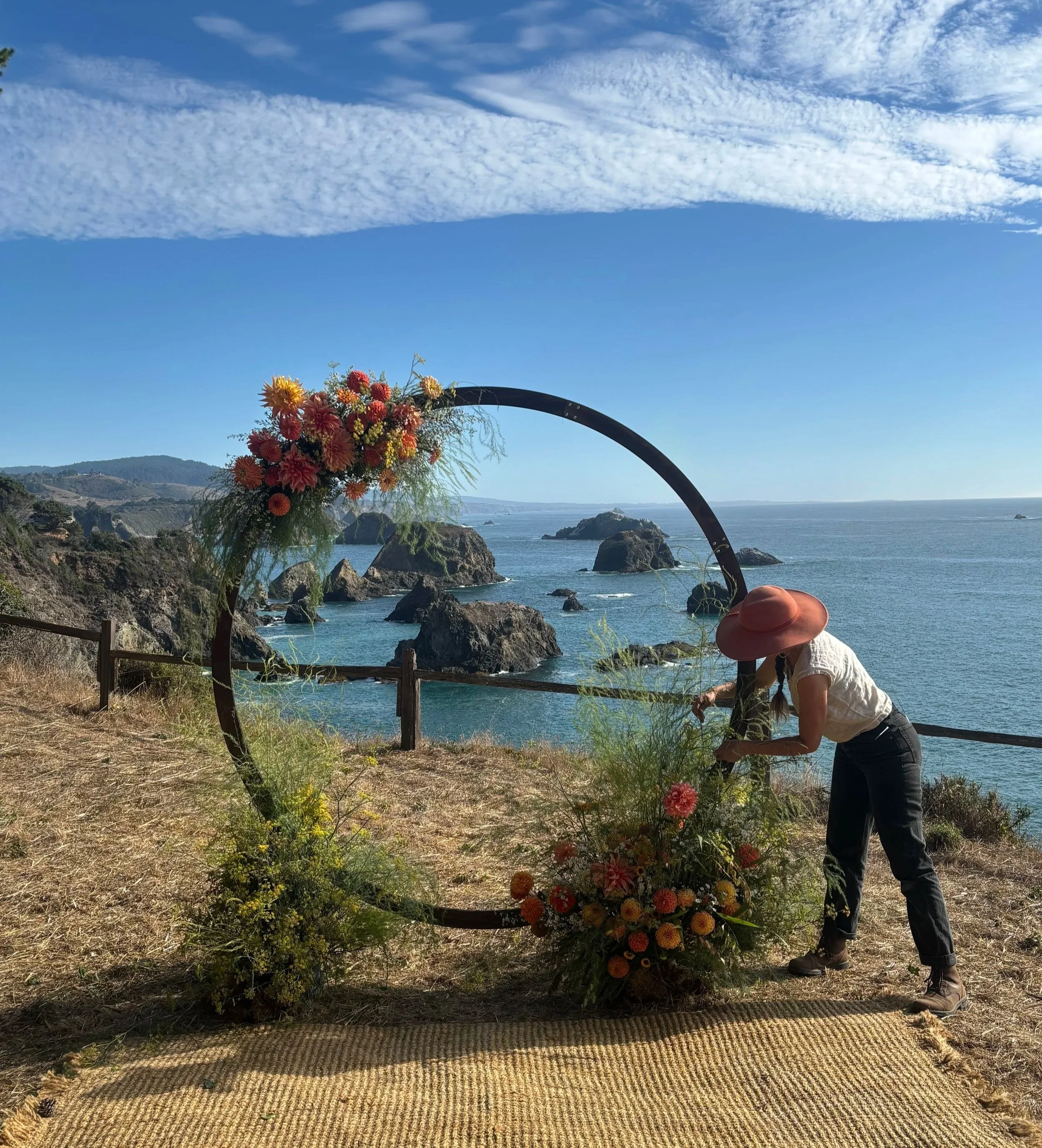 Florist designing ceremony arch in Elk CA on the Mendocino Coast