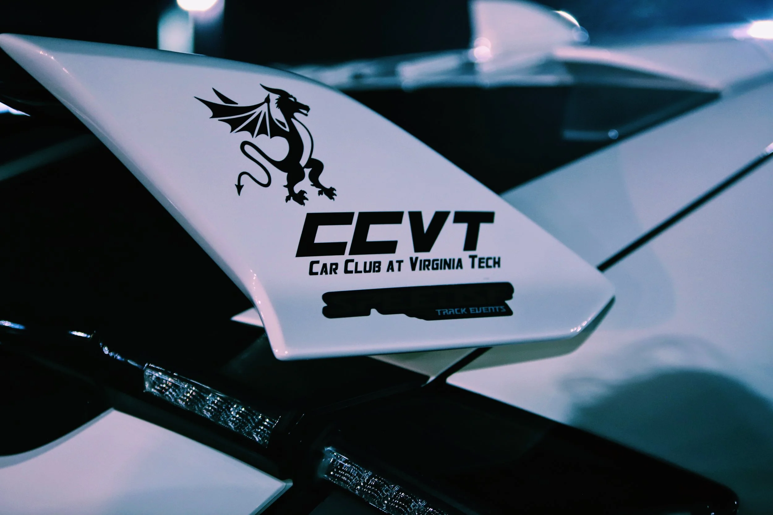 Close-up of a white air vent with a Virginia Tech Car Club sticker featuring a dragon logo and the text 'CCTV Car Club at Virginia Tech'.
