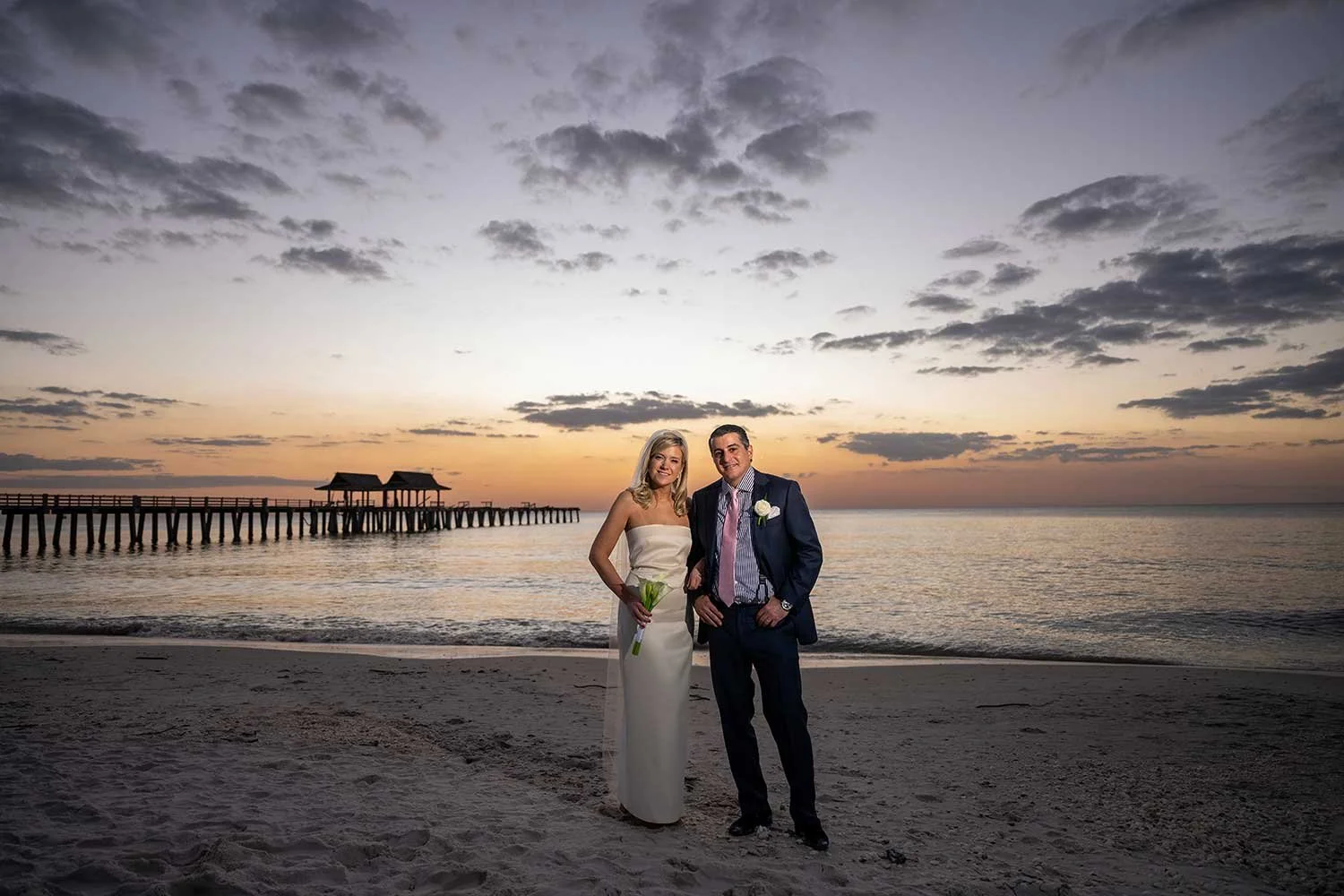 Bride and Groom standing in front of Naples Pier