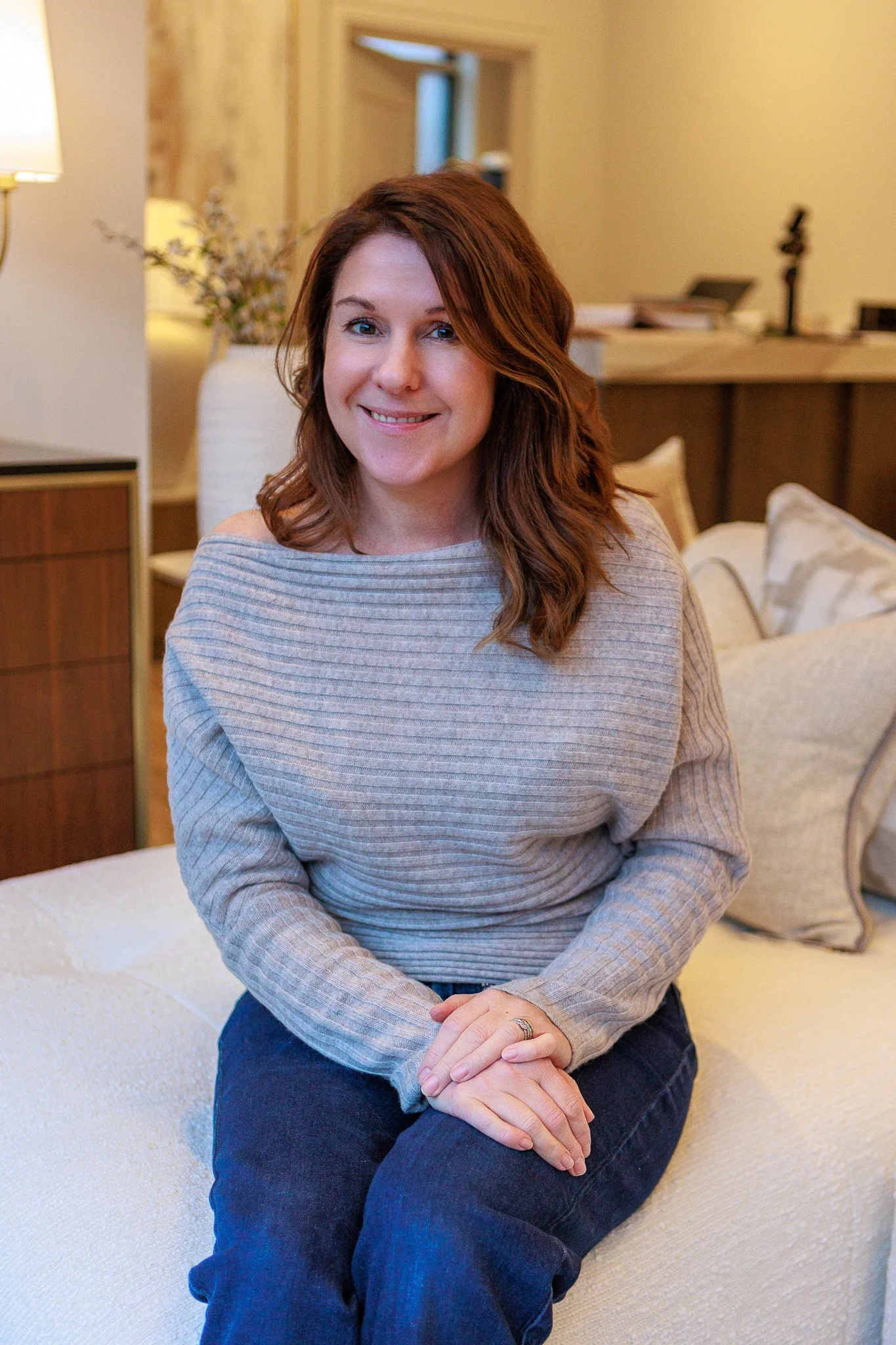 Woman sitting on a sofa in a cozy living room.