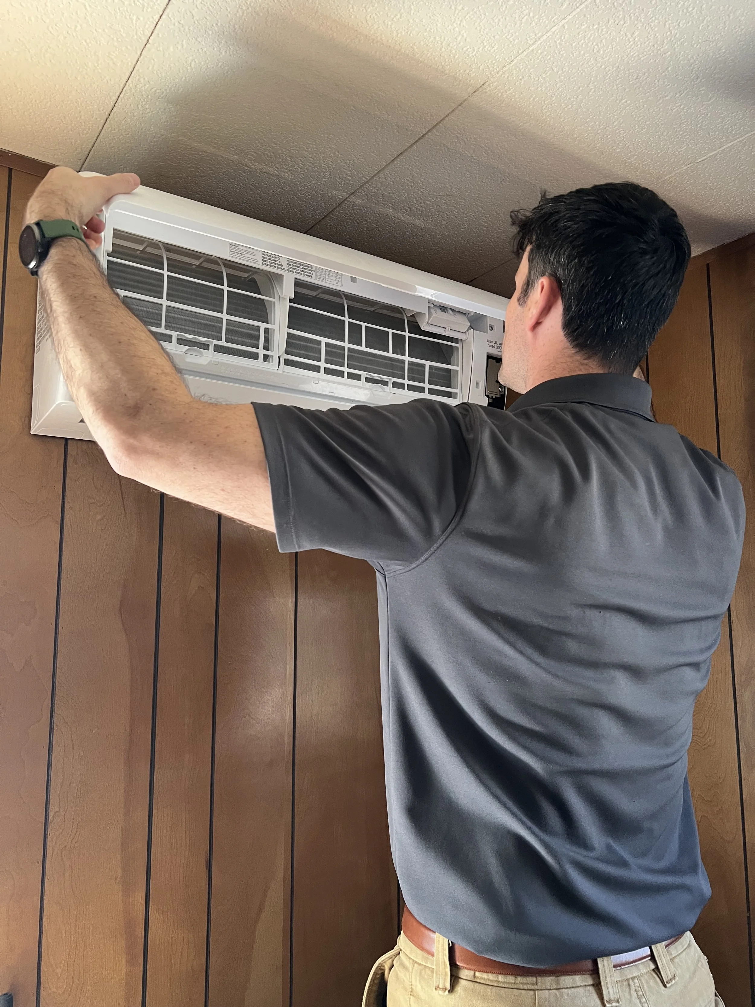 Bobby, co-owner of Blanca Electric Homes, helps install a wall head heat pump unit in Cuchara, CO