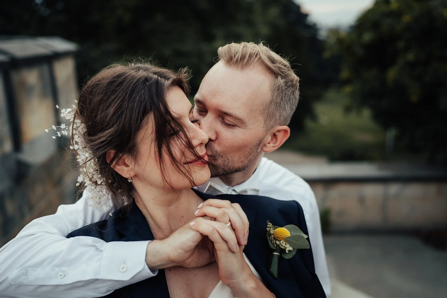 Bride laughing as the groom hugs her from behind outdoors in Berlin