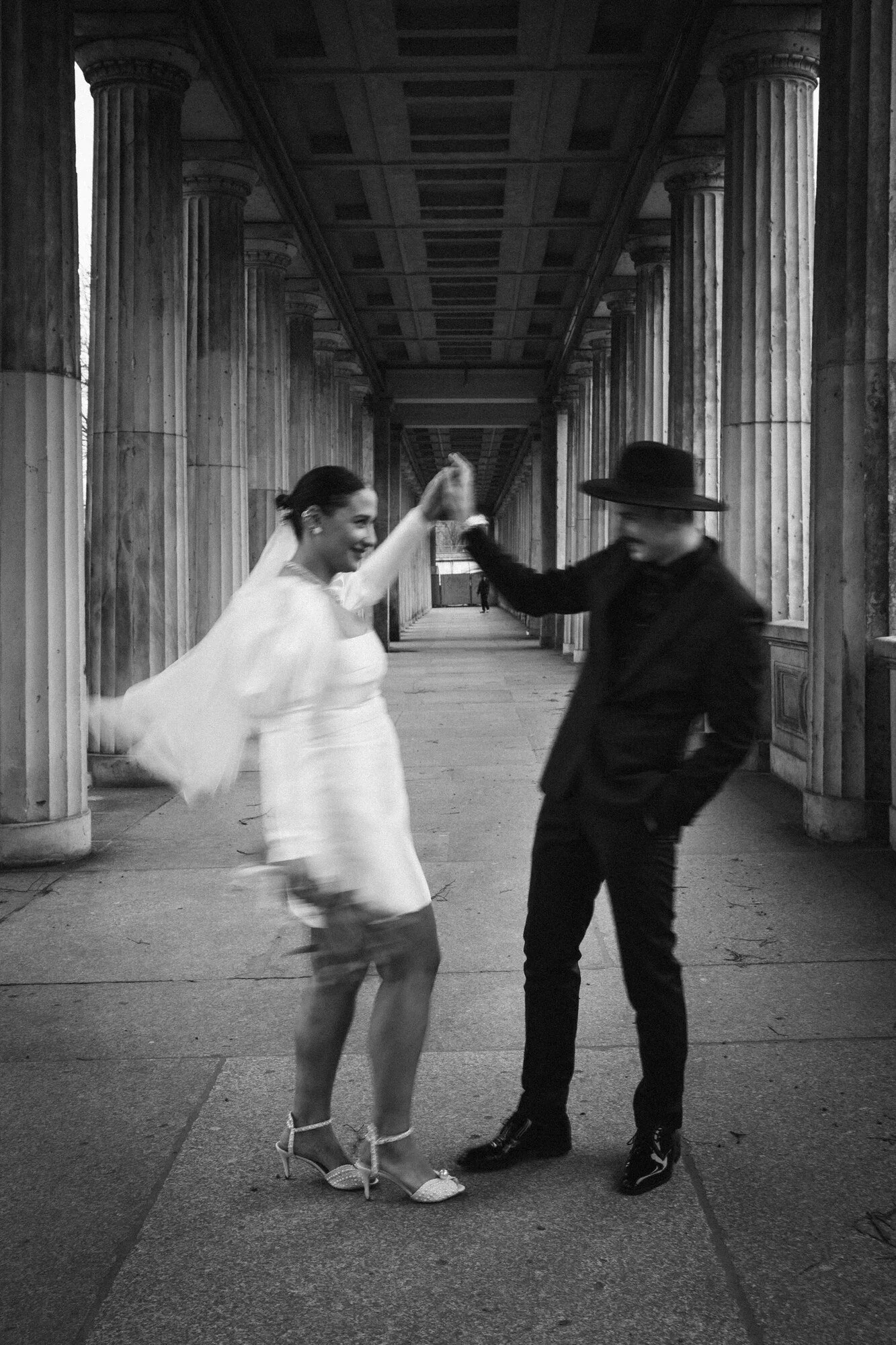 Couple dancing under a stone colonnade in Berlin, in black and white