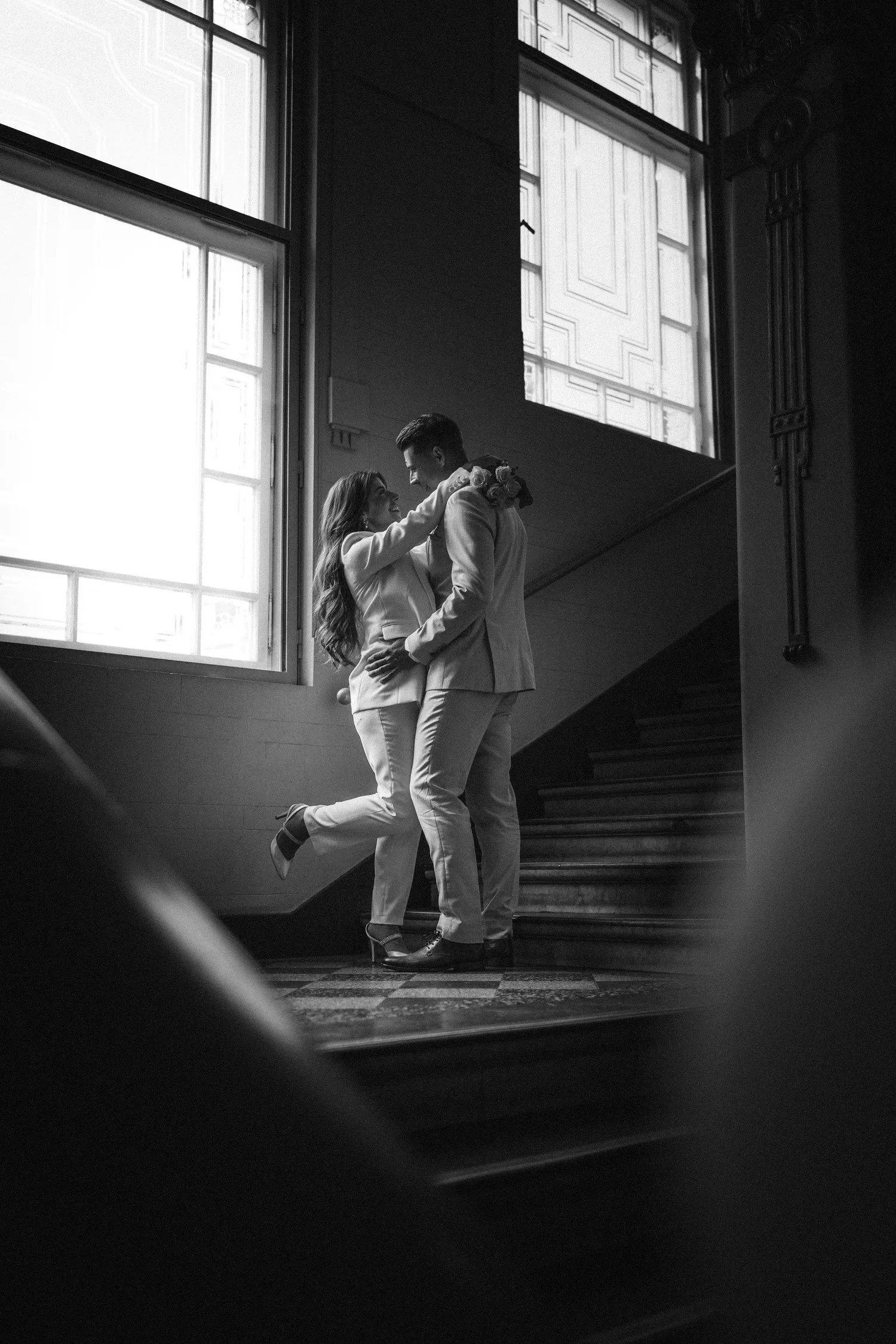 Couple embracing on a staircase, in black and white