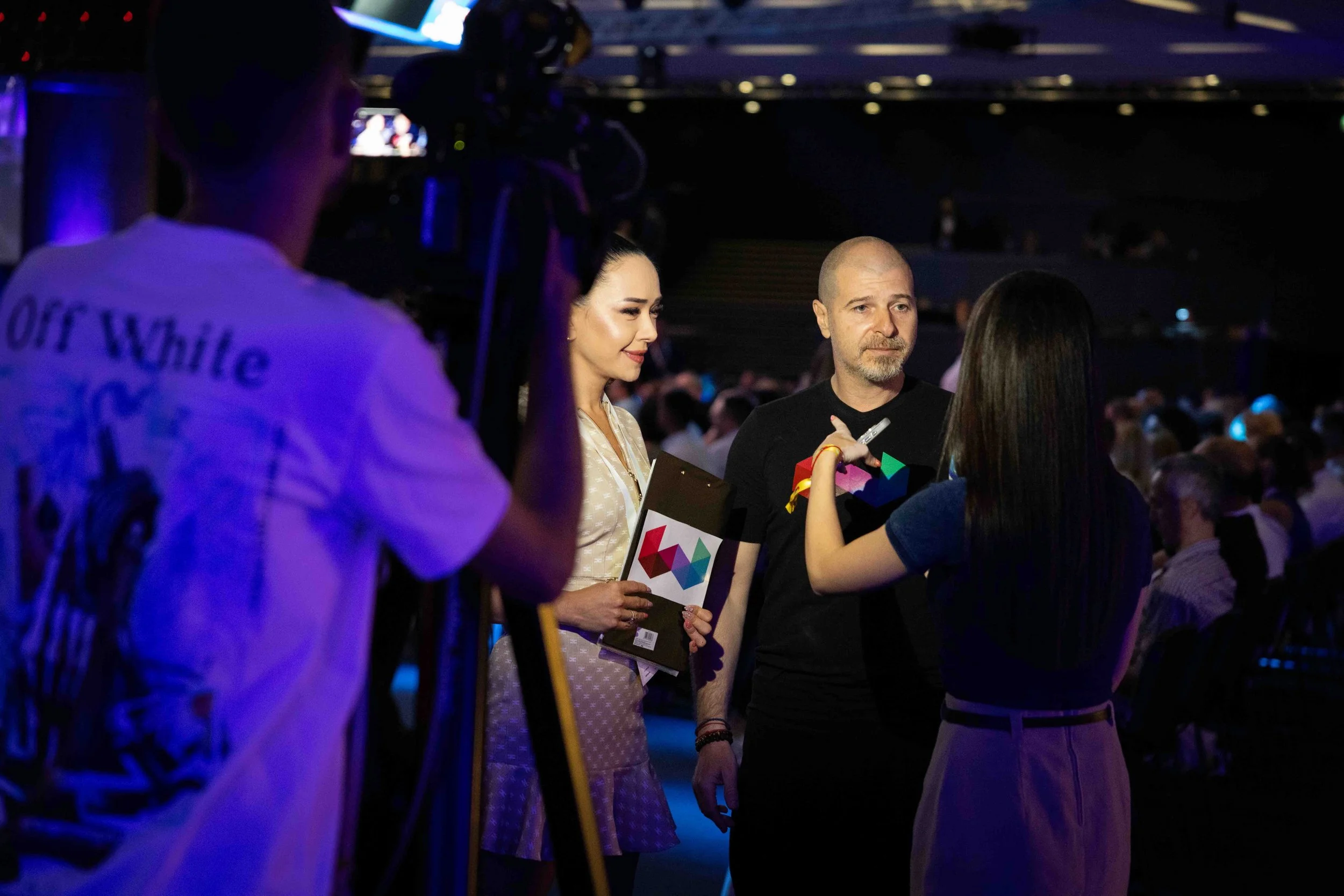 Behind-the-scenes moment at Webit 2025 showing a media interview with two speakers and a camera crew.
