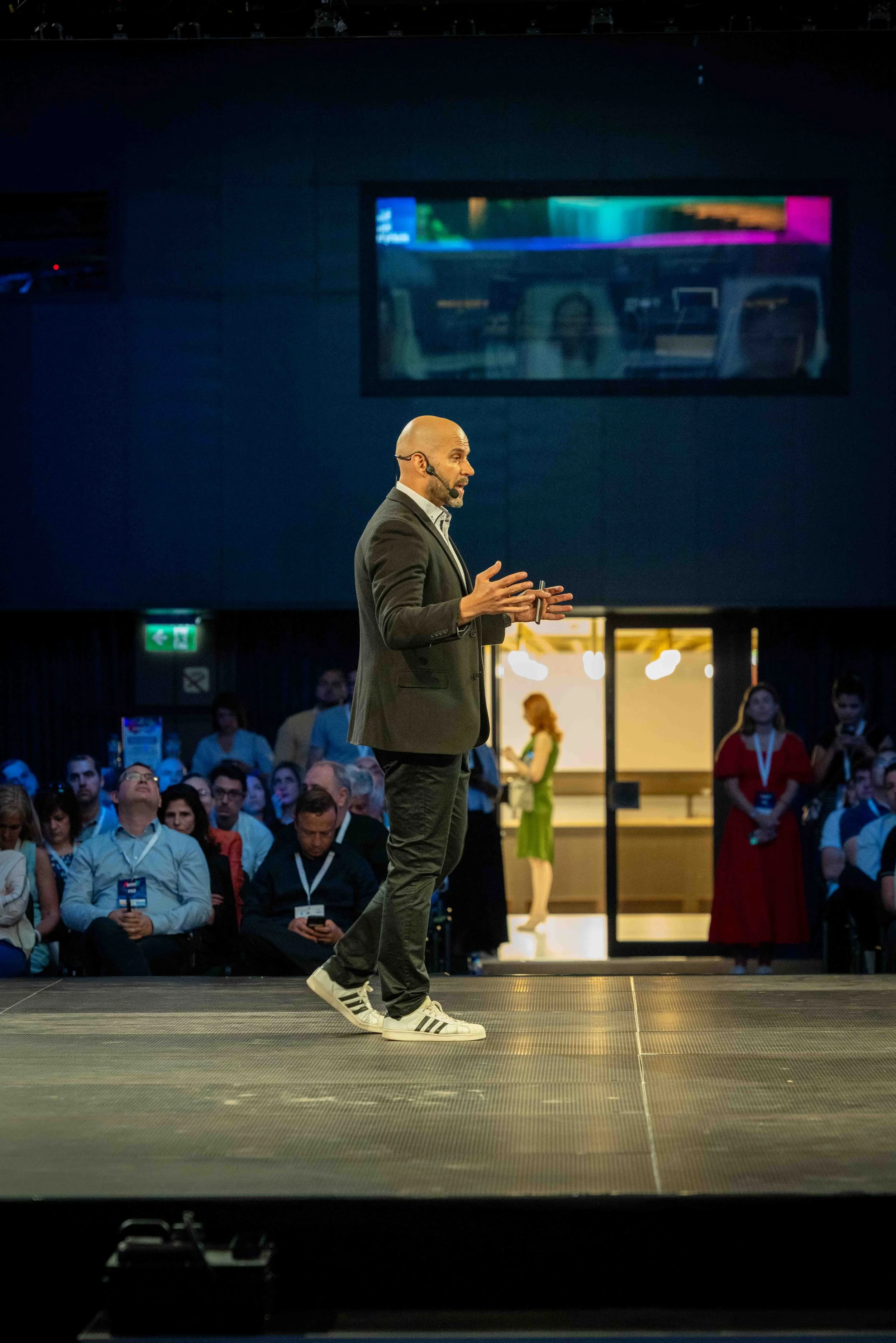 Keynote speaker presenting on stage at Webit 2025, with an engaged audience in the background.