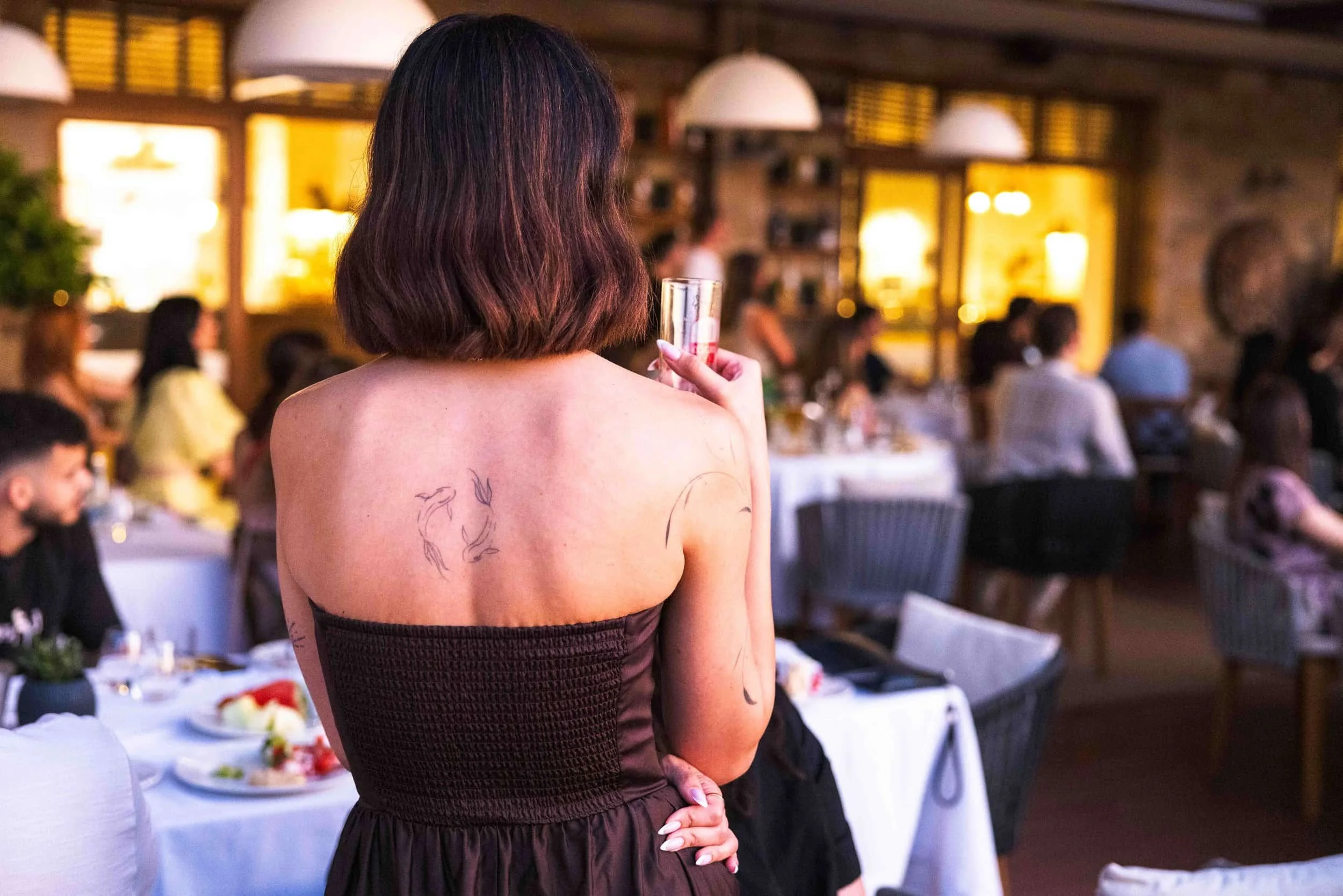 Guest holding a drink during an evening reception in Sozopol
