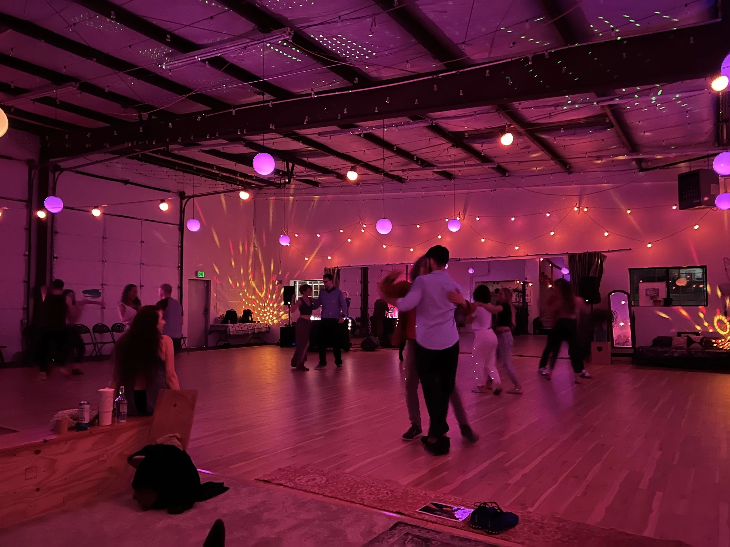 Dancers under pink and purple lights at the Hut