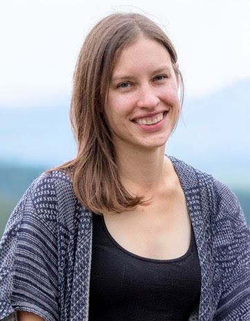 Vanessa Oleksow, RCC-ACS smiling with shoulder-length hair wearing a black top and patterned cardigan outdoors.