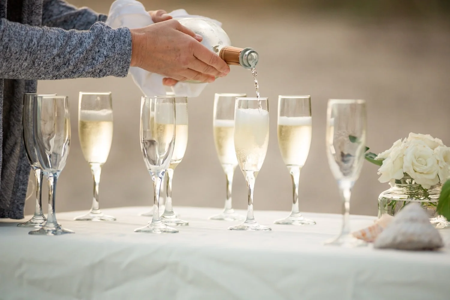 Vow renewal on Santa Barbara beach pouring champagne
