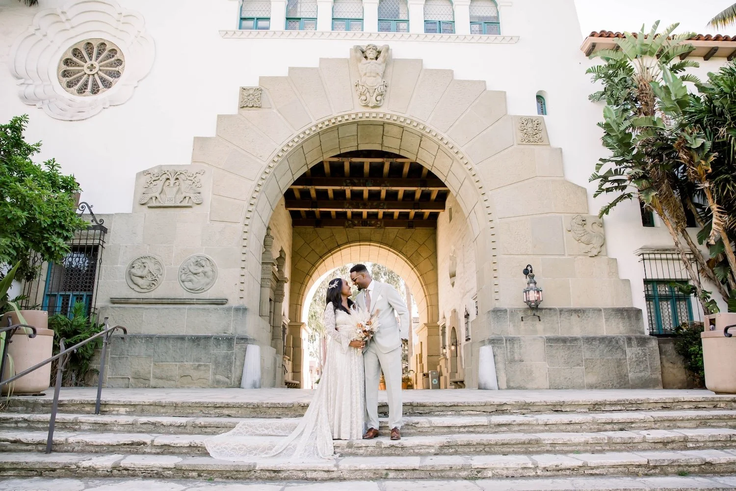 newlyweds in front of main arch at Santa Barbara courthouse