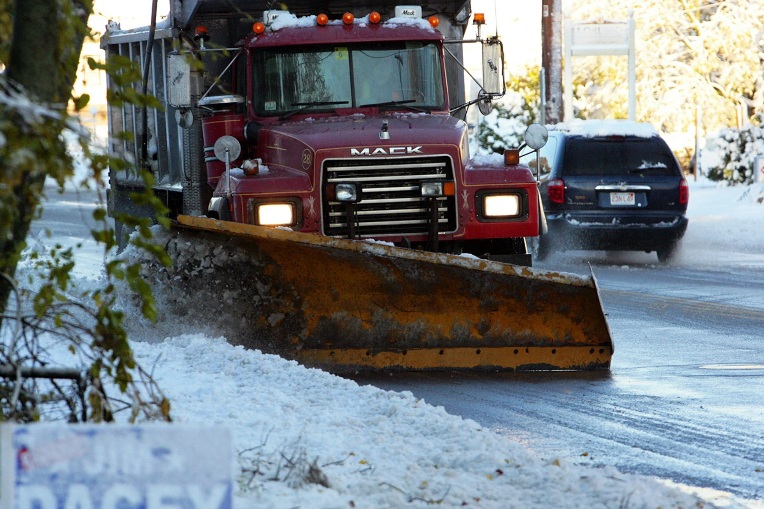 Stock photo of a dump truck fitted with a snow plow clearing a road