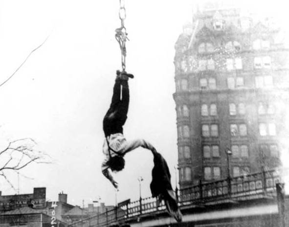 Performer suspended upside down above downtown Pittsburgh
