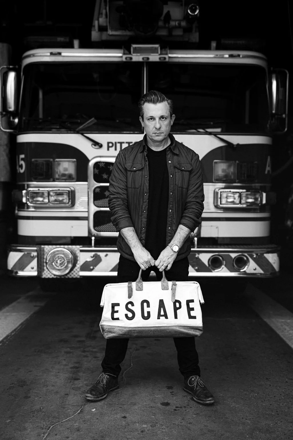 Lee Terbosic holding his ESCAPE case beside a Pittsburgh firetruck