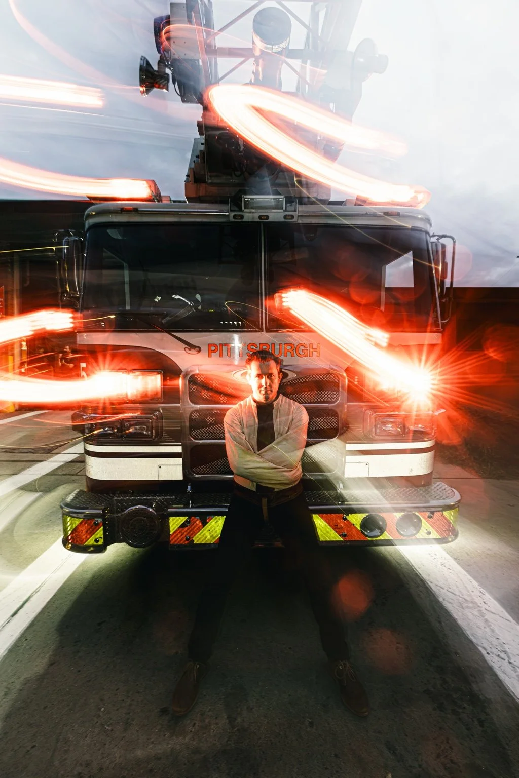 Lee Terbosic in front of a Pittsburgh firetruck with streaks of red and white light
