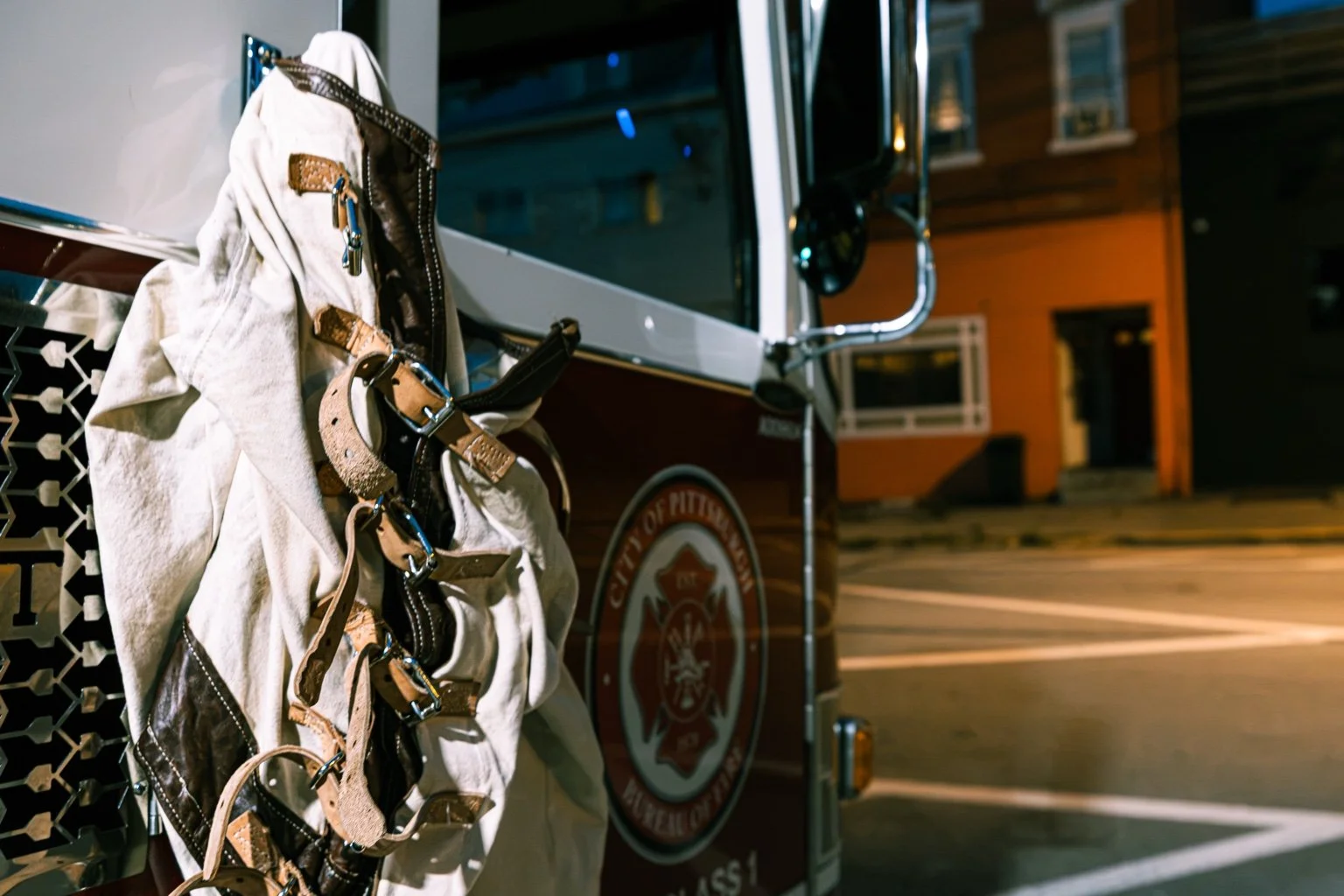 Close-up of a straitjacket beside the City of Pittsburgh fire department emblem