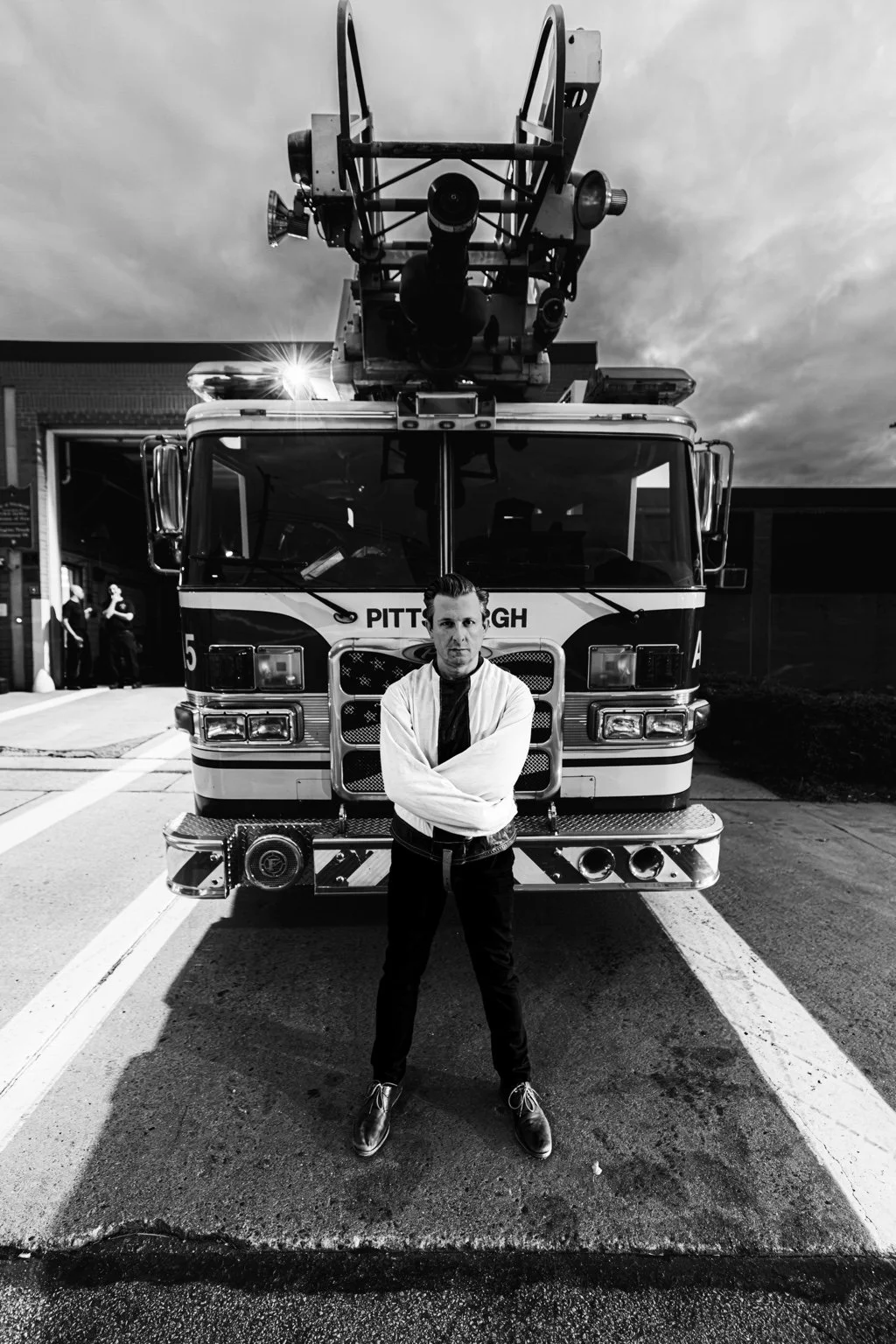 Lee Terbosic in a straitjacket beneath a Pittsburgh firetruck ladder