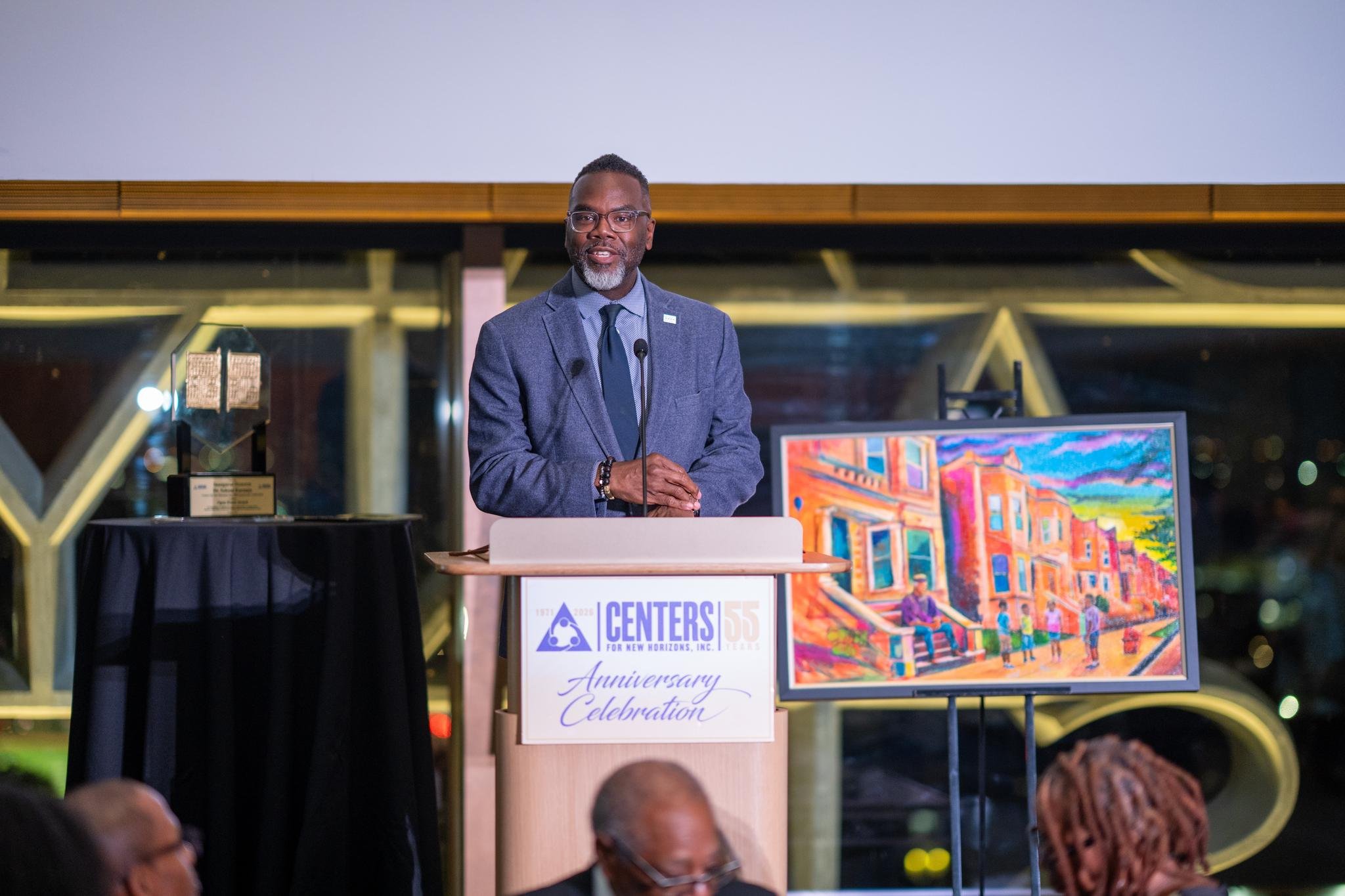 An image of Chicago Mayor Brandon Johnson speaking at the event in front of the commissioned artwork by Paul Branton