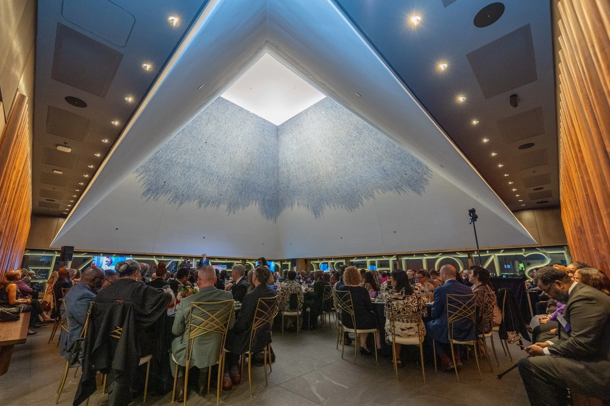 Event attendees sitting at tables in the Sky Room at the Obama Presidential Center Museum