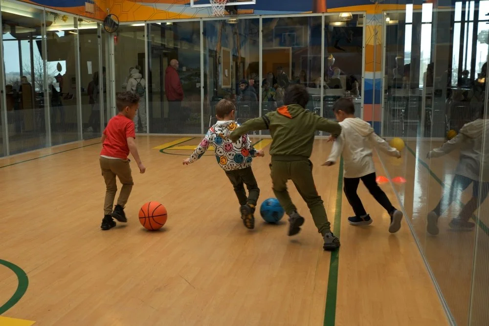 Novastar students playing soccer in their indoor gymnasium on campus.