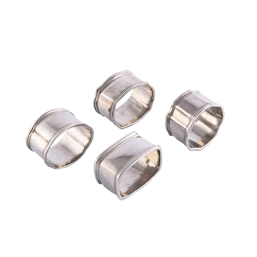 Four silver metal napkin rings on a white background.